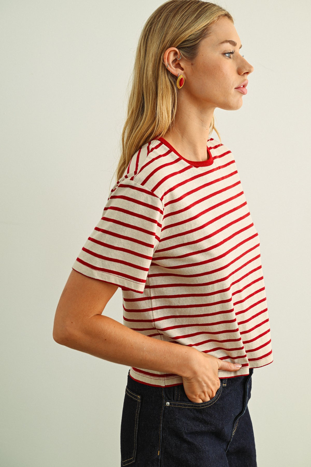 Woman wearing a red and white striped shirt against a plain background
