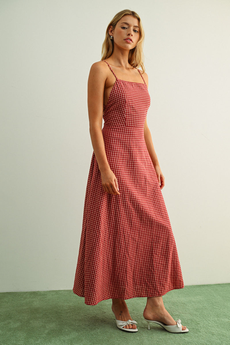 Woman wearing a red checkered dress against a plain background