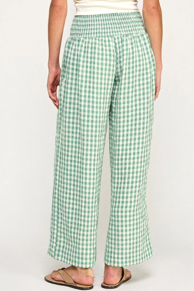Green checkered pants worn by a person on a white background