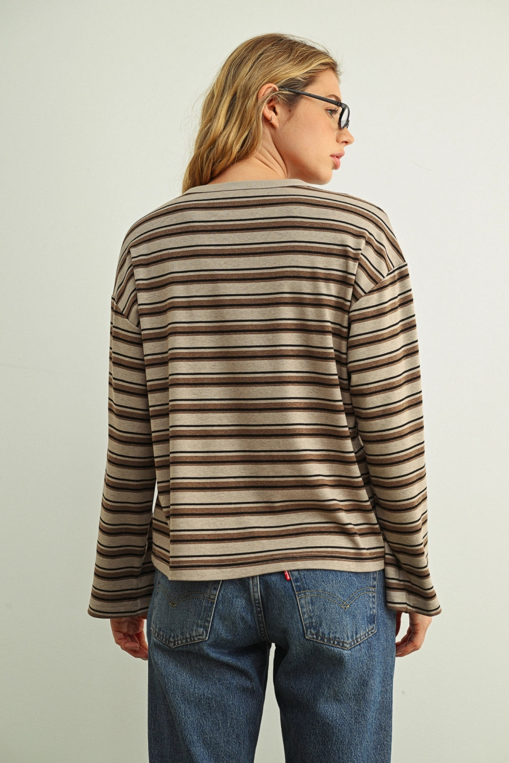Woman wearing a brown striped tee with jeans