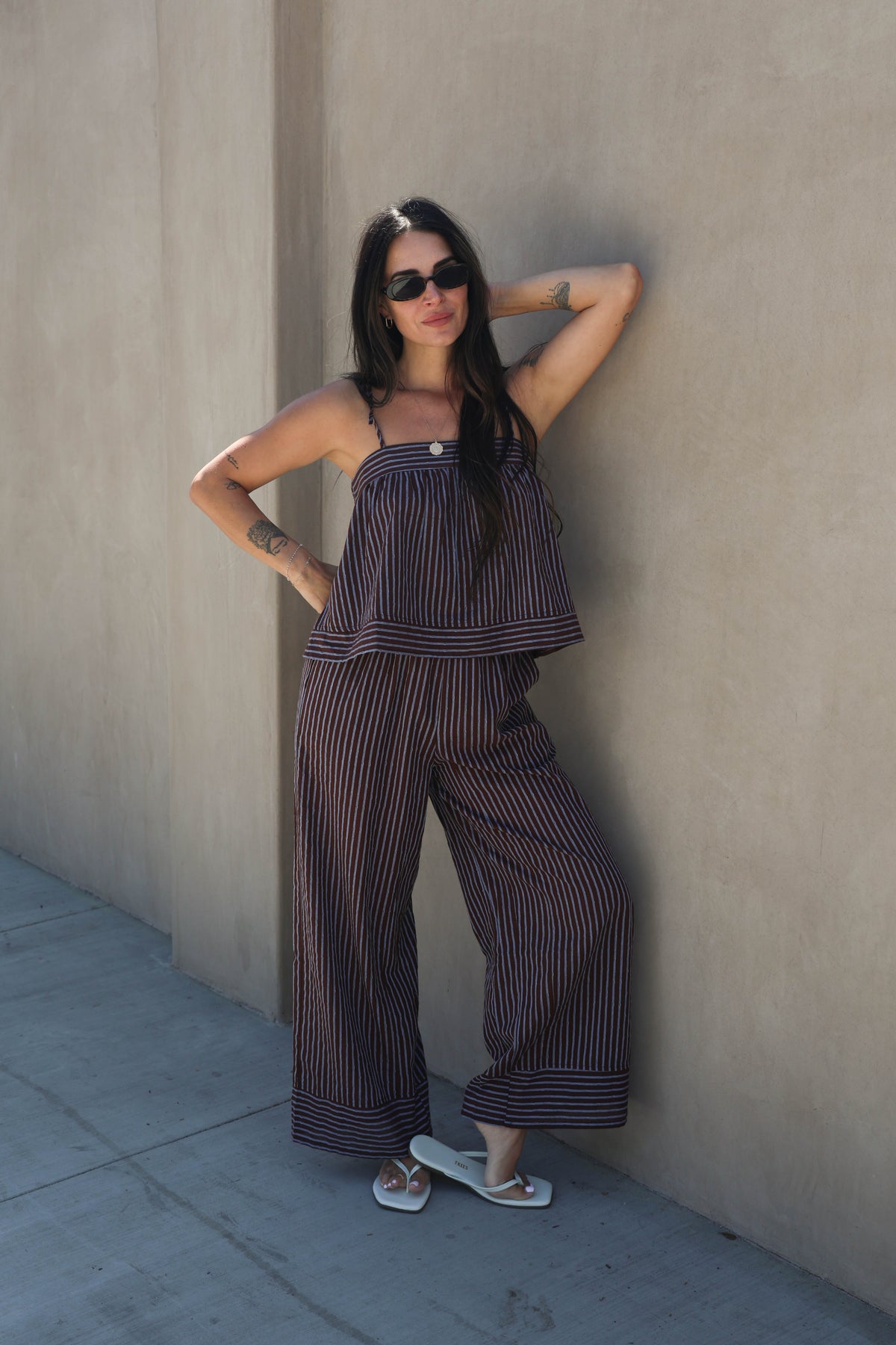 Woman wearing a striped set against a plain background