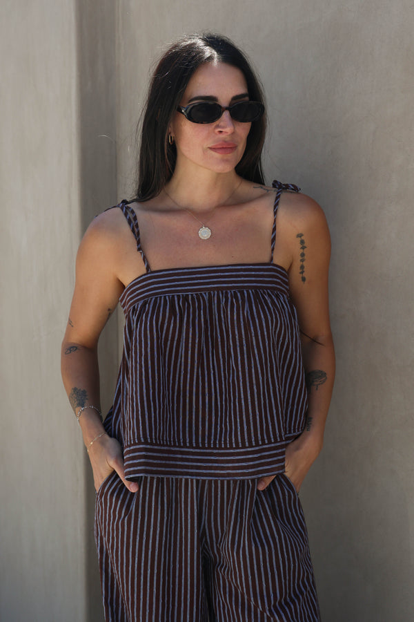 Woman wearing a striped set against a plain background