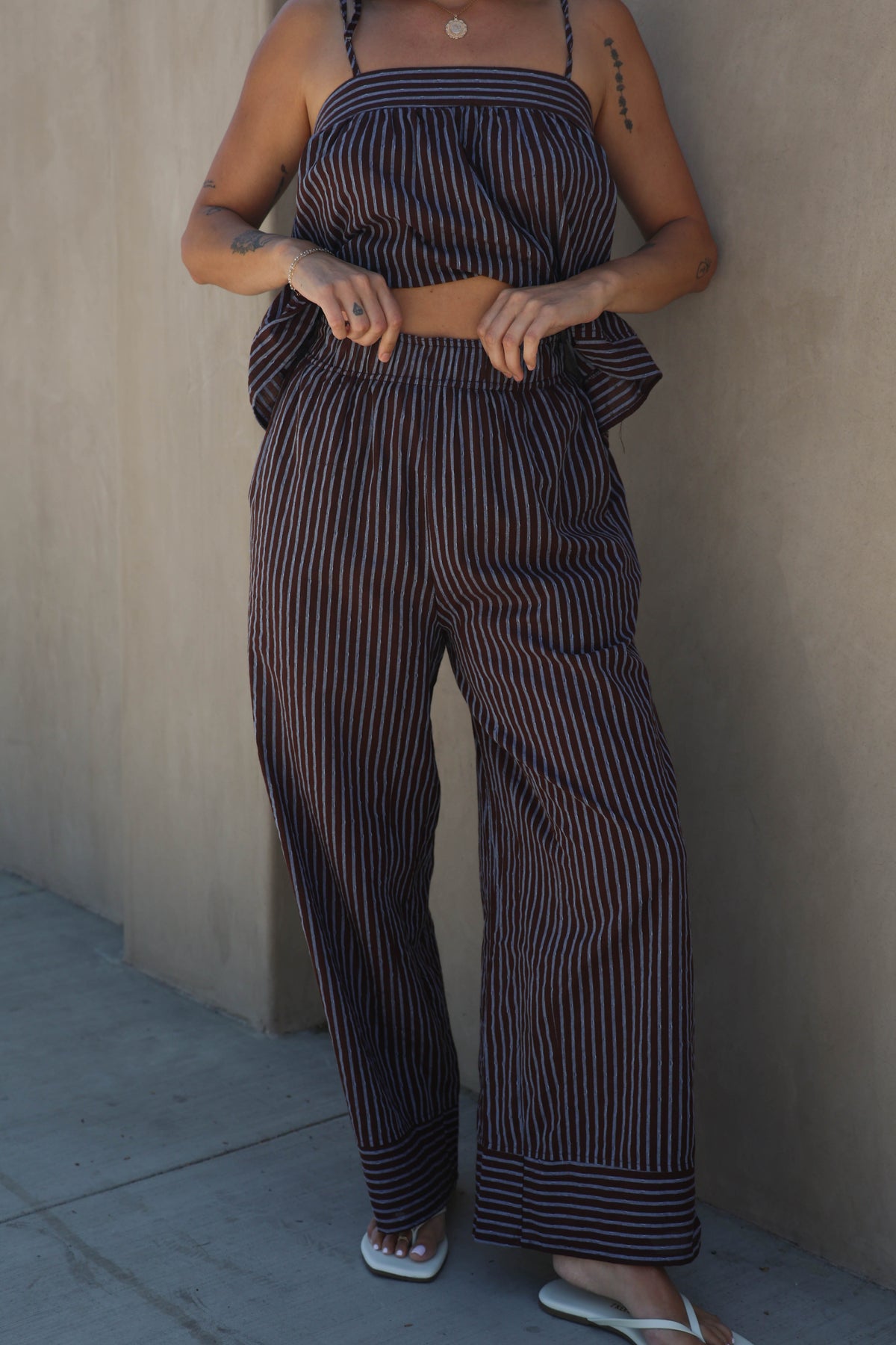 Woman wearing a striped set against a plain background
