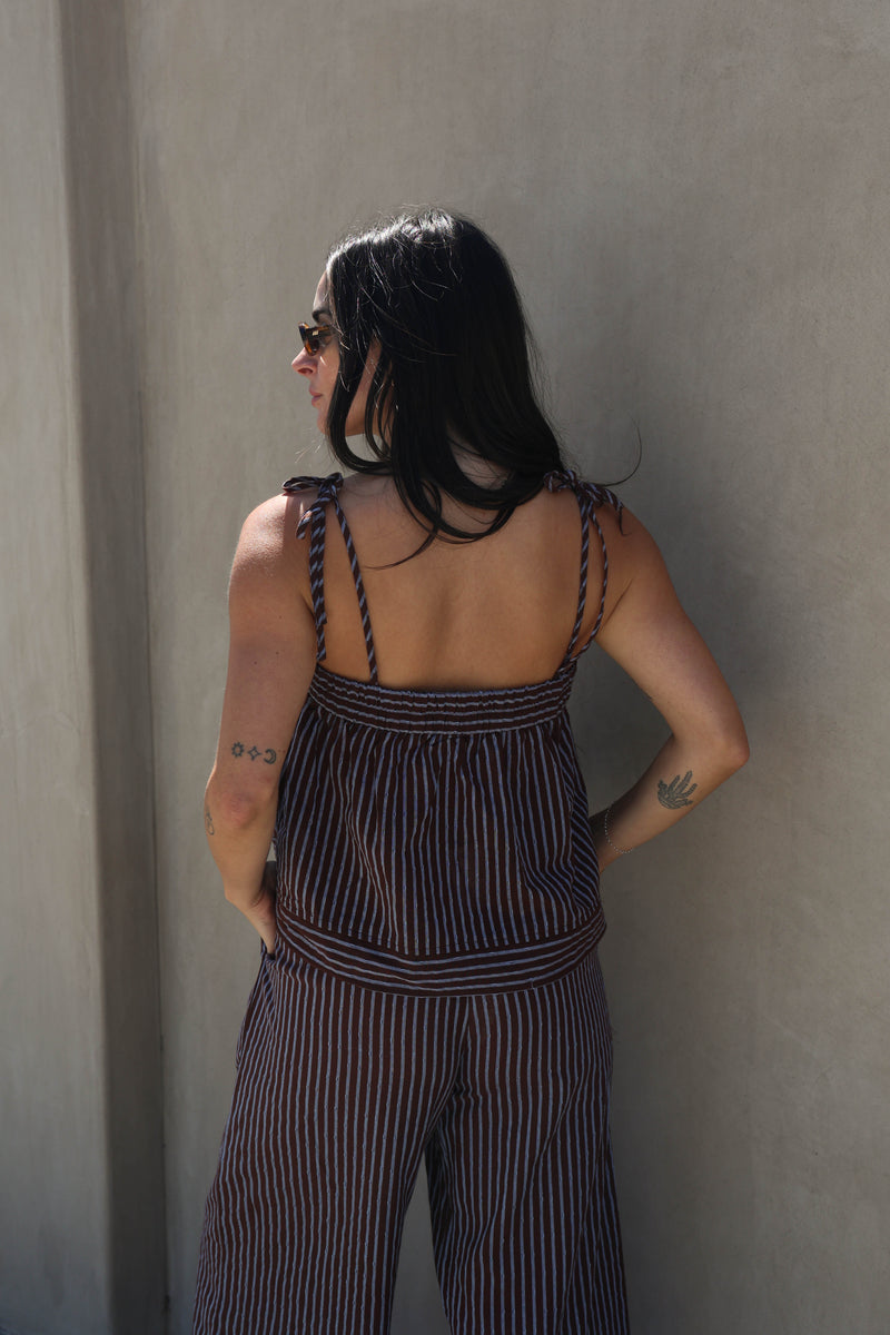 Woman wearing a striped set against a plain background