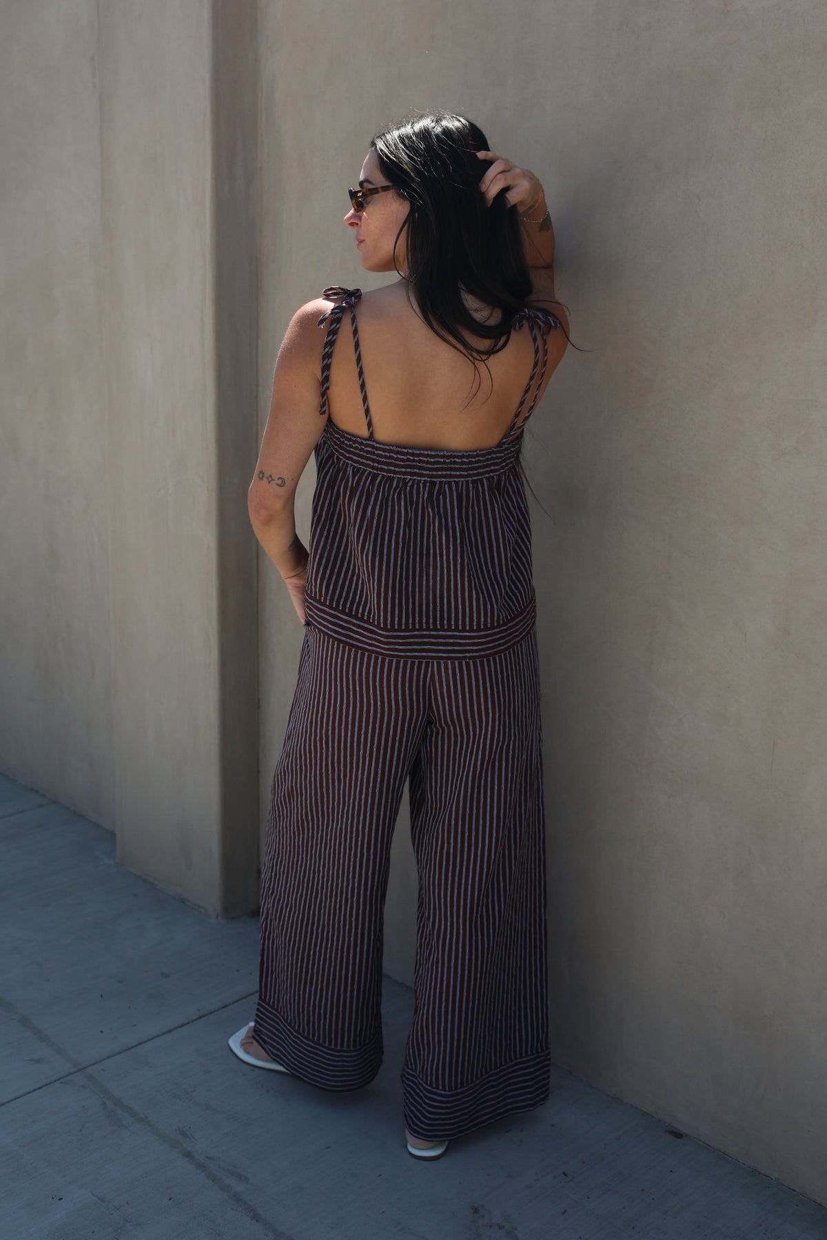 Woman wearing a striped set against a plain background