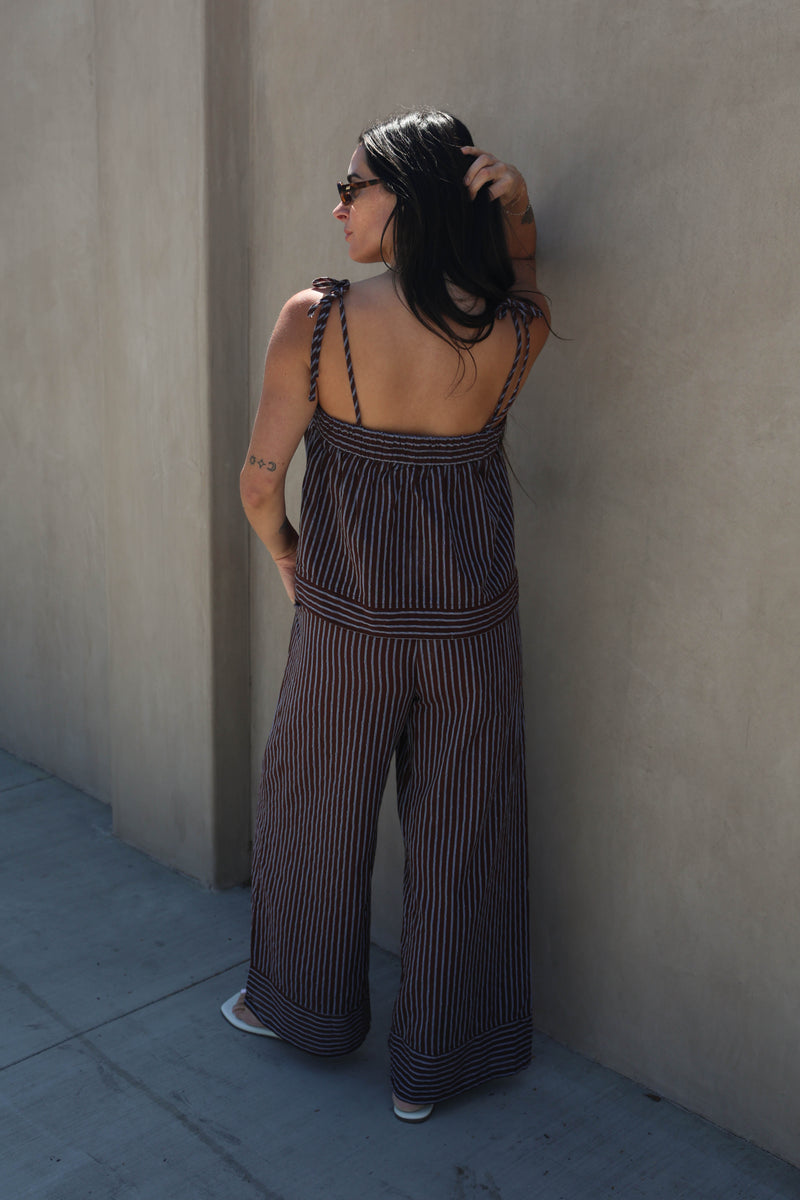 Woman wearing a striped set against a plain background