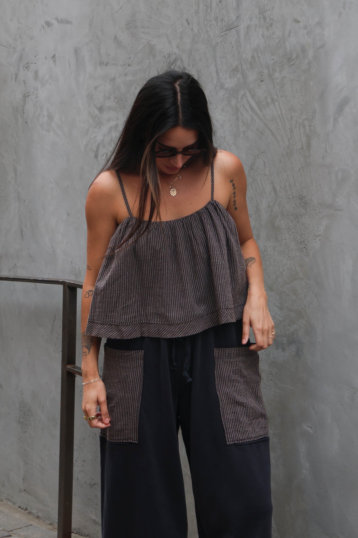 Woman wearing a layered outfit against a gray wall