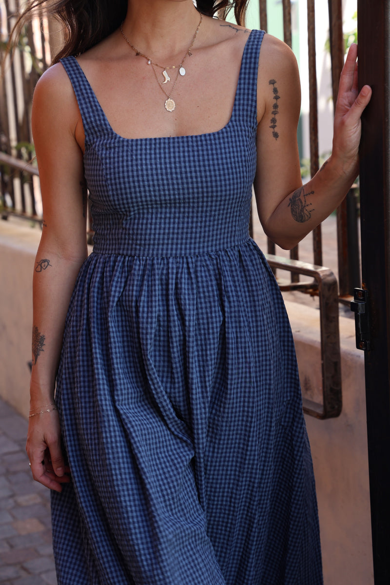 Person wearing a blue checkered dress with a blurred background
