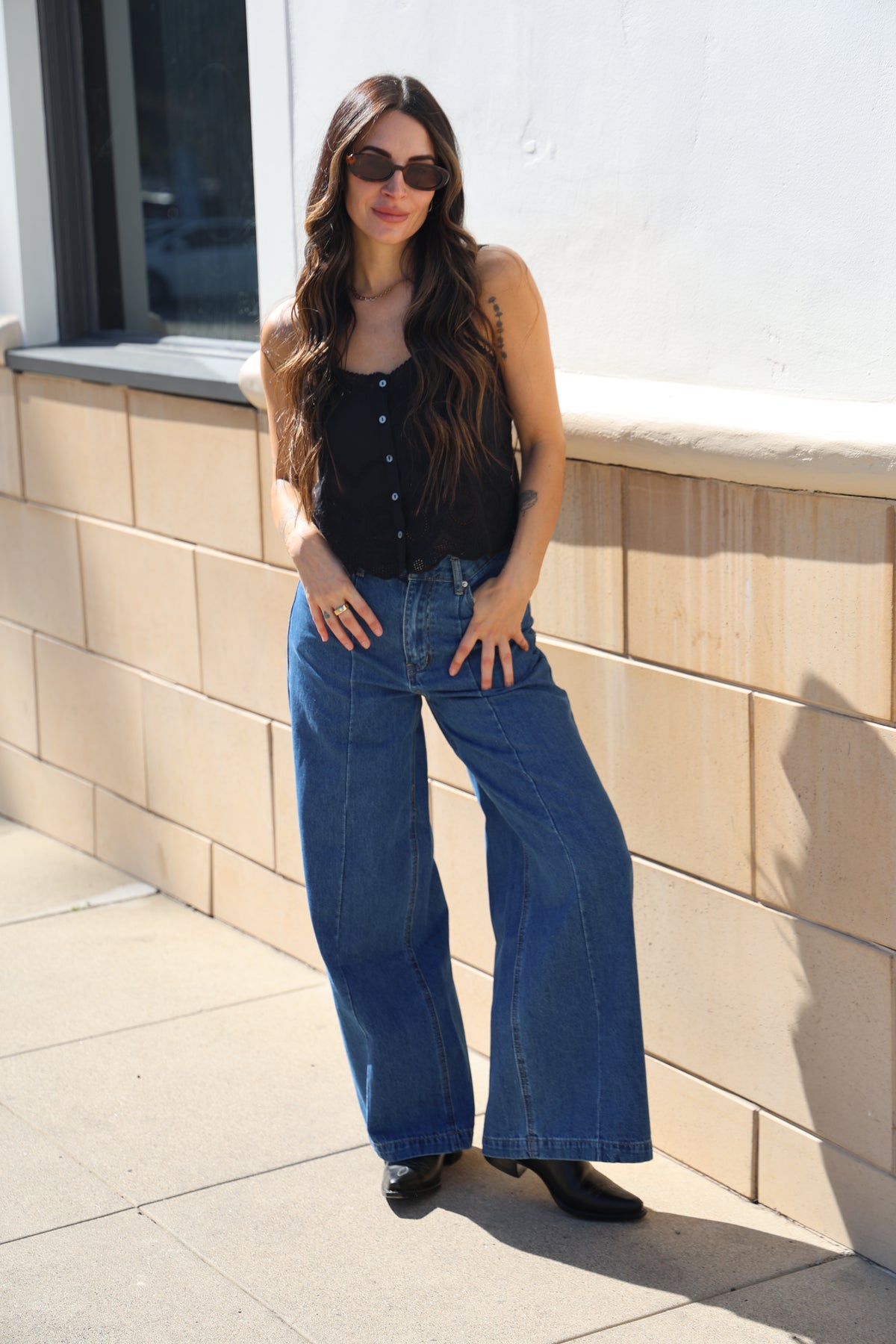 Person wearing blue jeans standing on a tiled floor