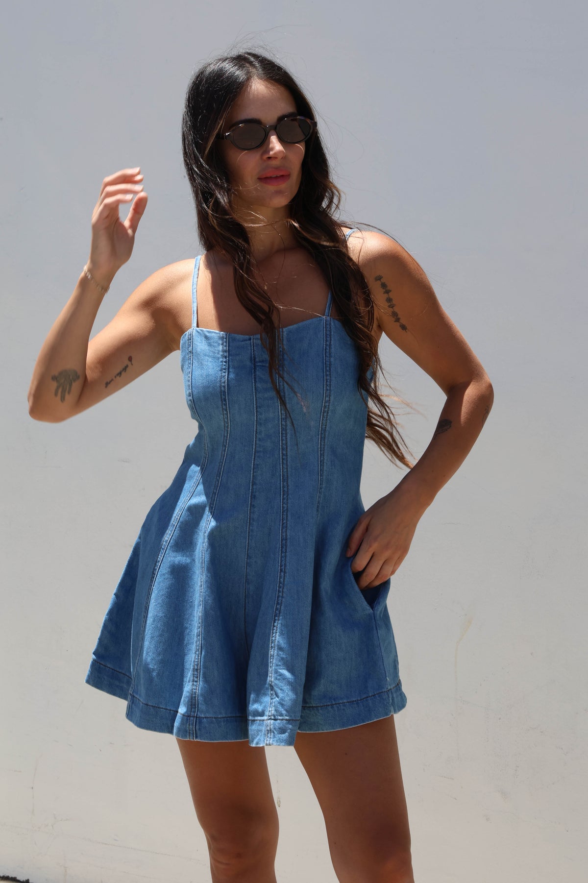 Woman wearing a blue denim dress against a white background