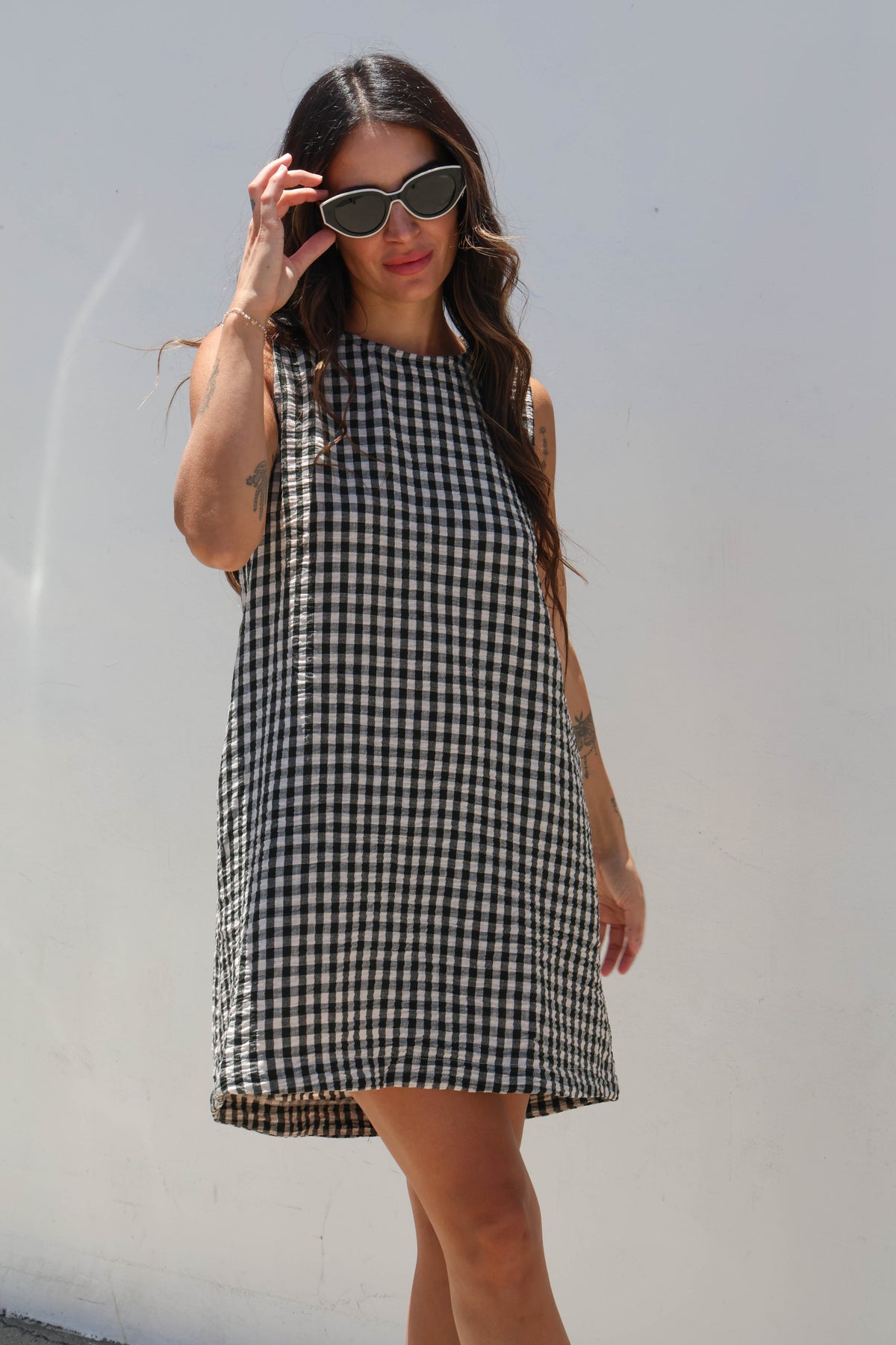 Woman wearing a black and white checkered dress against a plain background