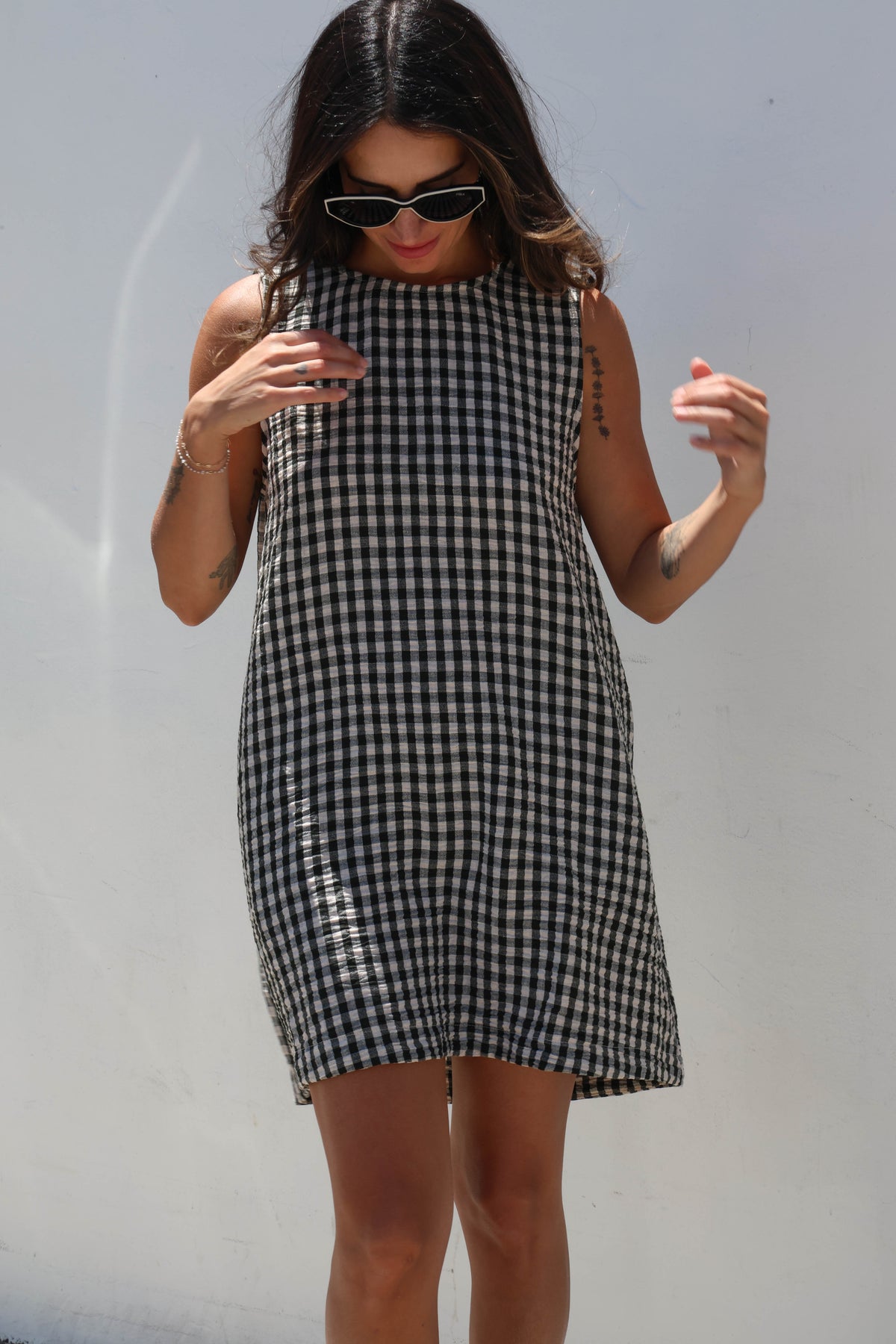 Woman wearing a black and white checkered dress against a plain background