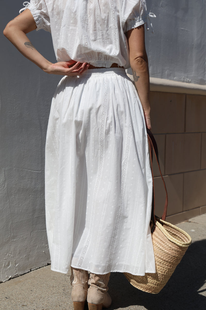 Person holding a large white sheet against a neutral background