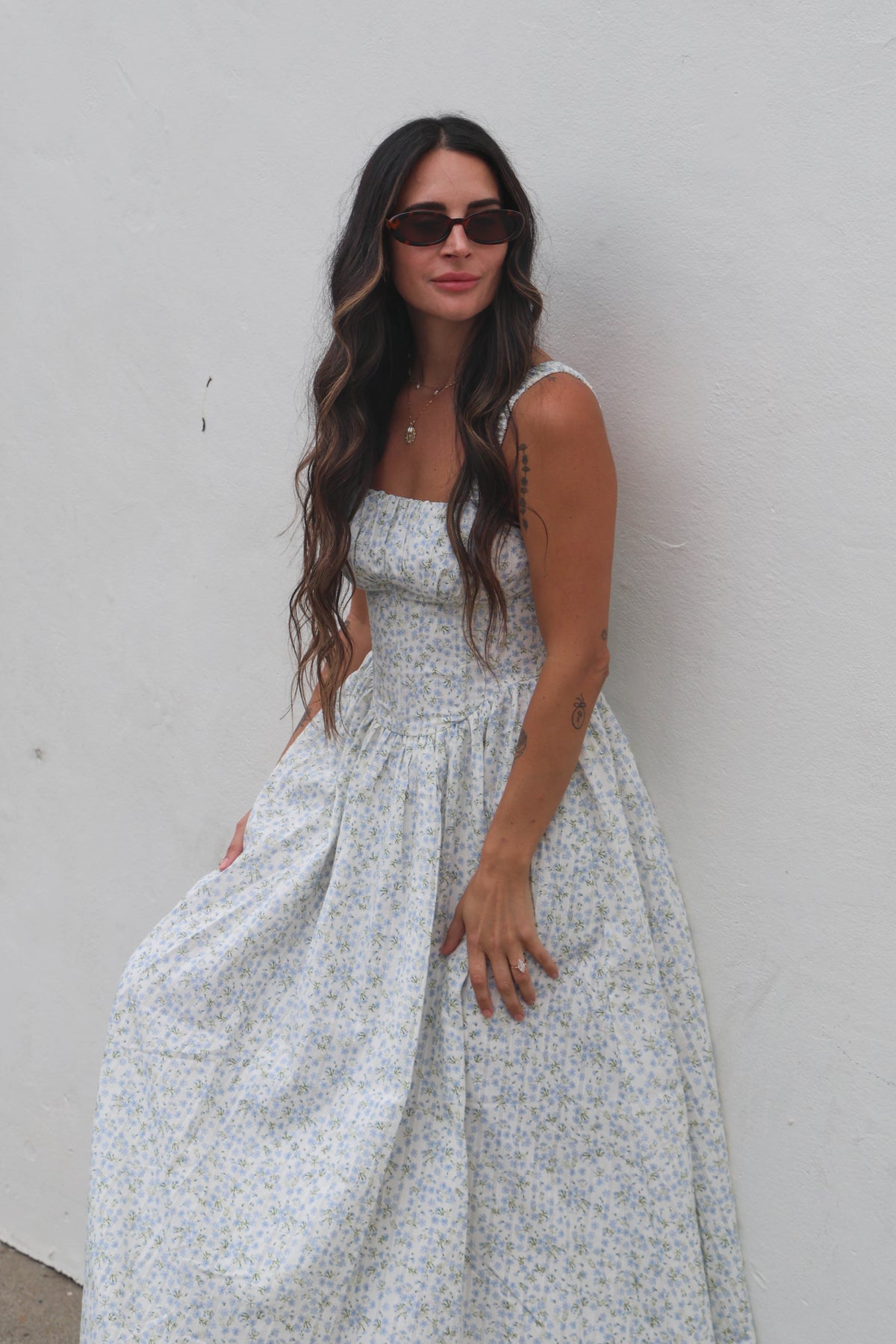 Woman wearing a floral dress against a plain background