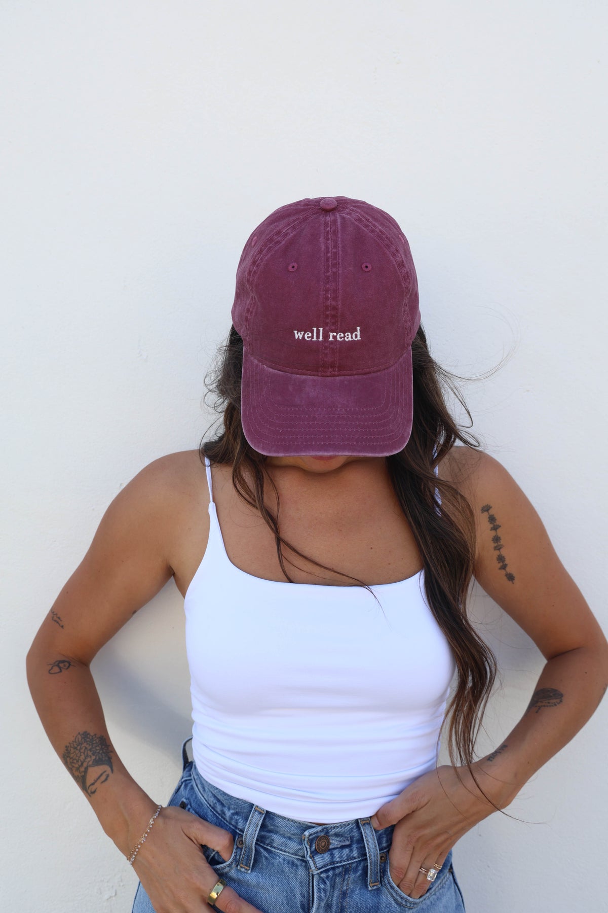 Woman wearing a hat against a white wall
