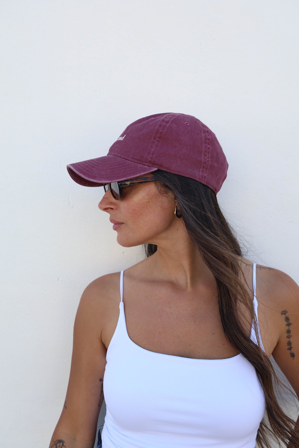 Woman wearing a hat against a white wall