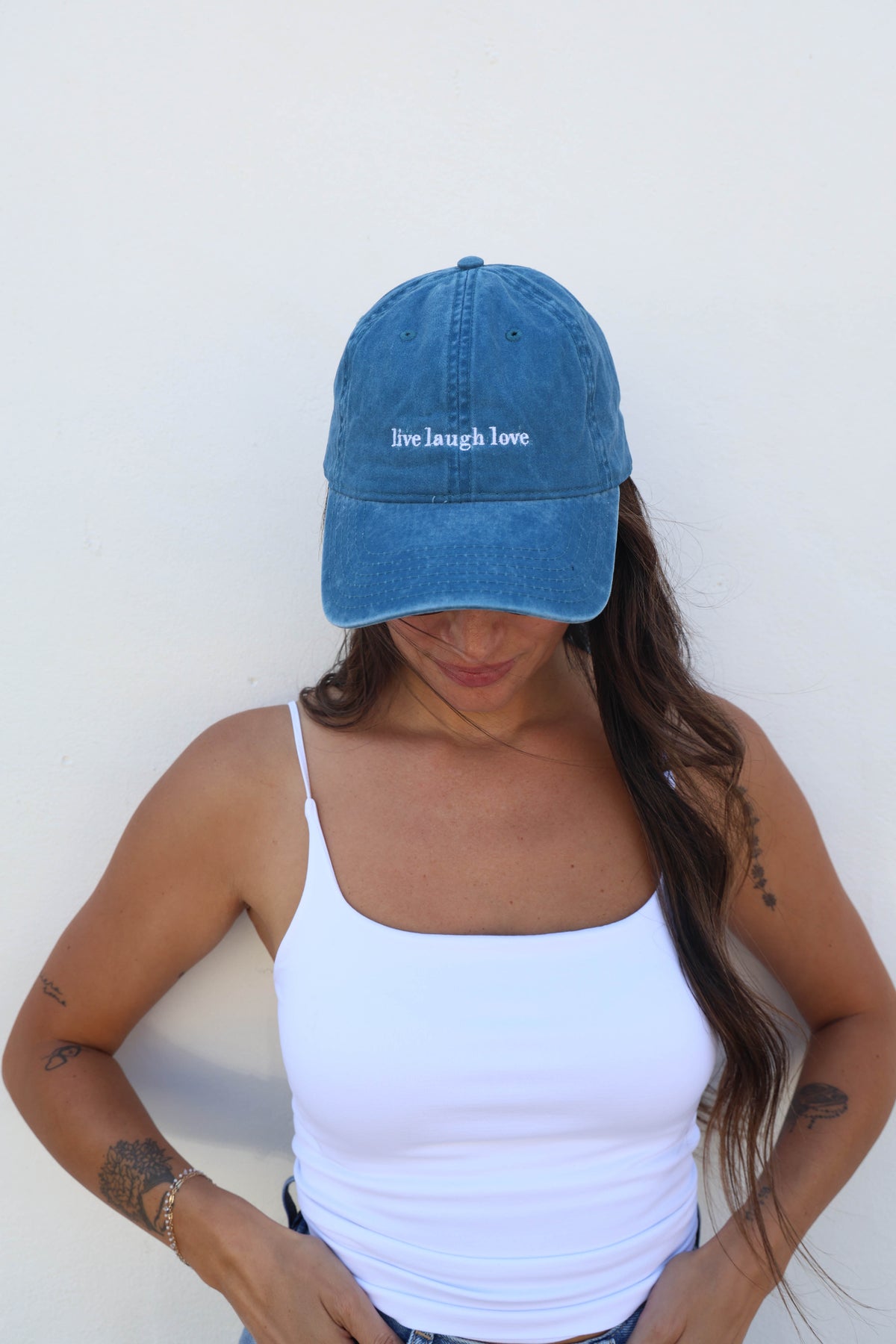 Woman wearing a hat against a white wall