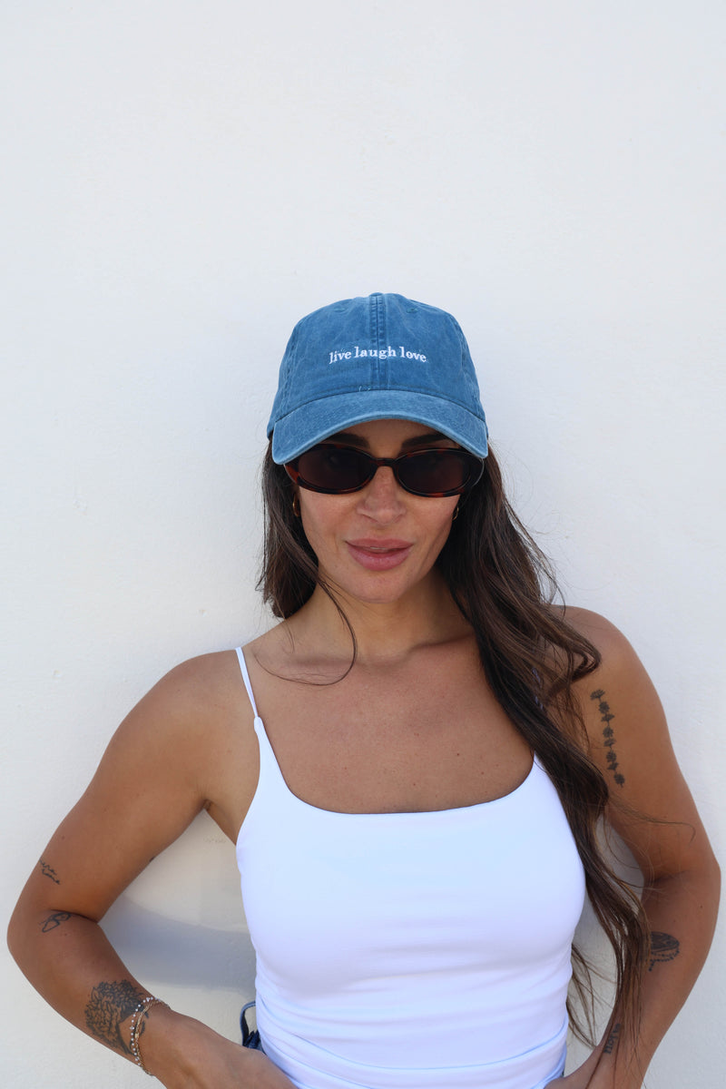 Woman wearing a hat against a white wall