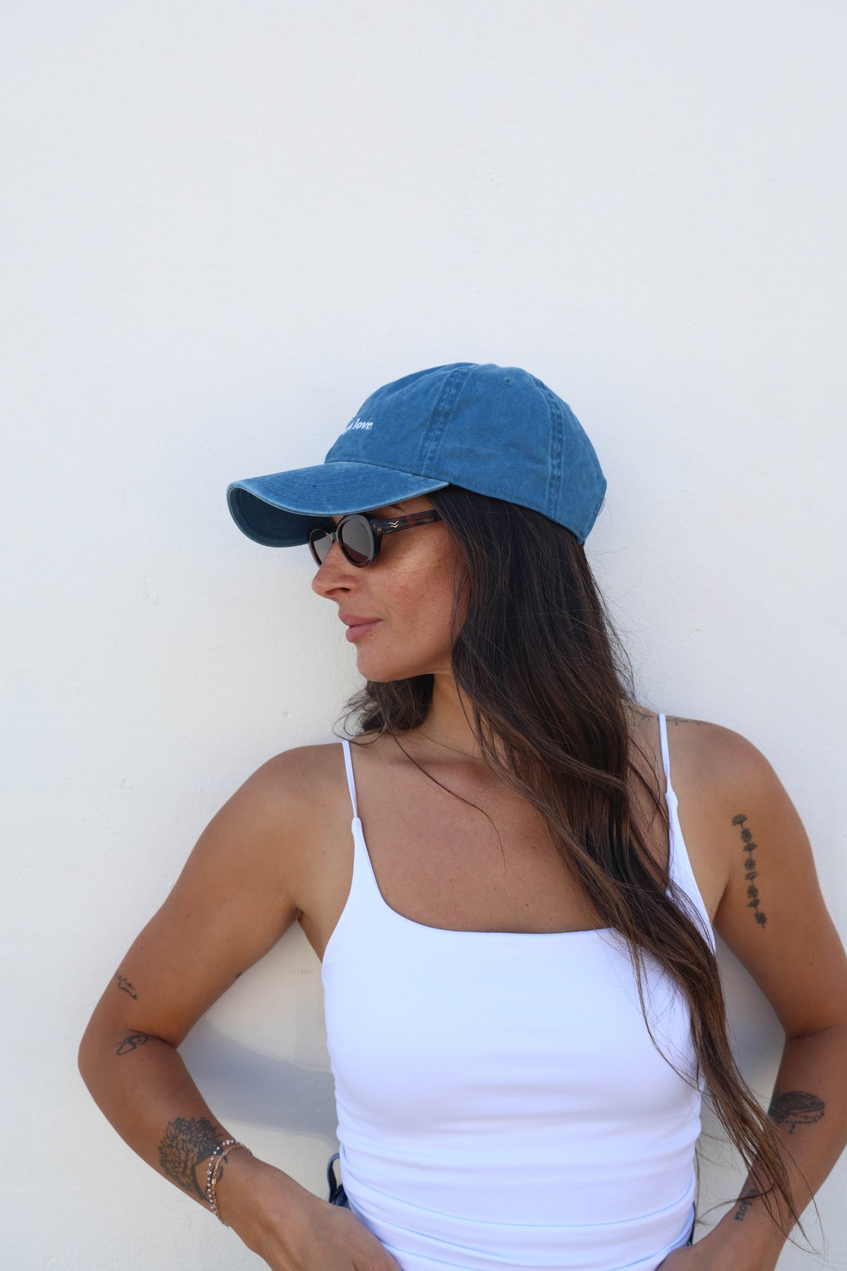 Woman wearing a hat against a white wall