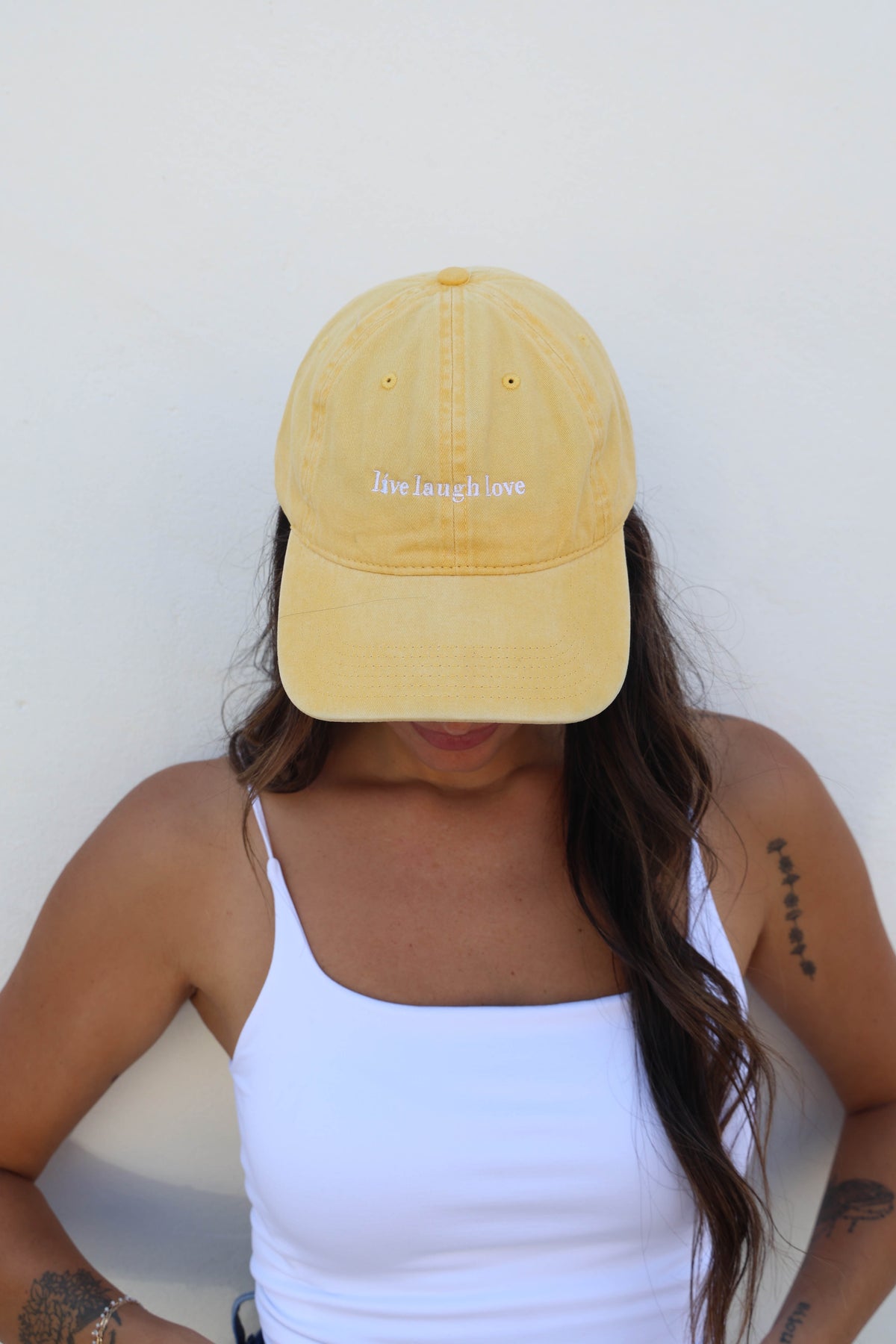 Woman wearing a hat against a white wall