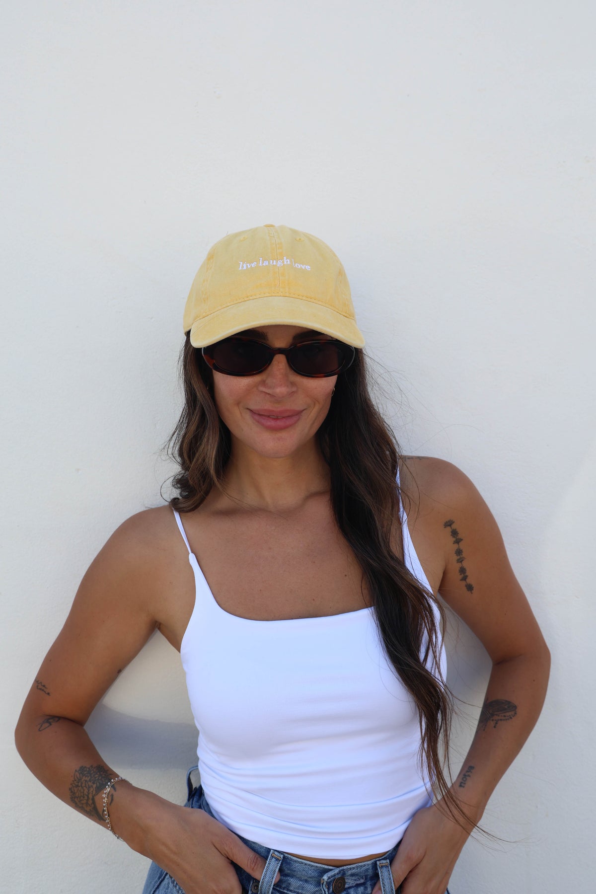 Woman wearing a hat against a white wall