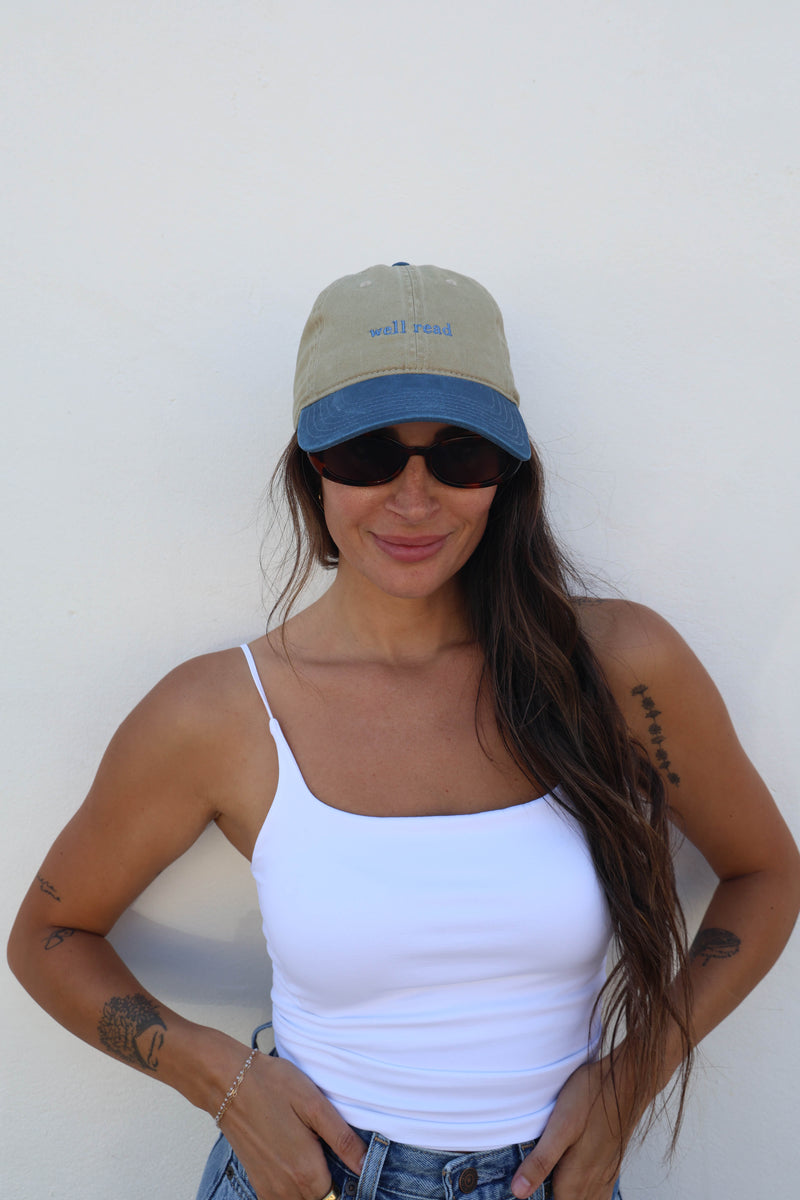 Woman wearing a hat against a white wall