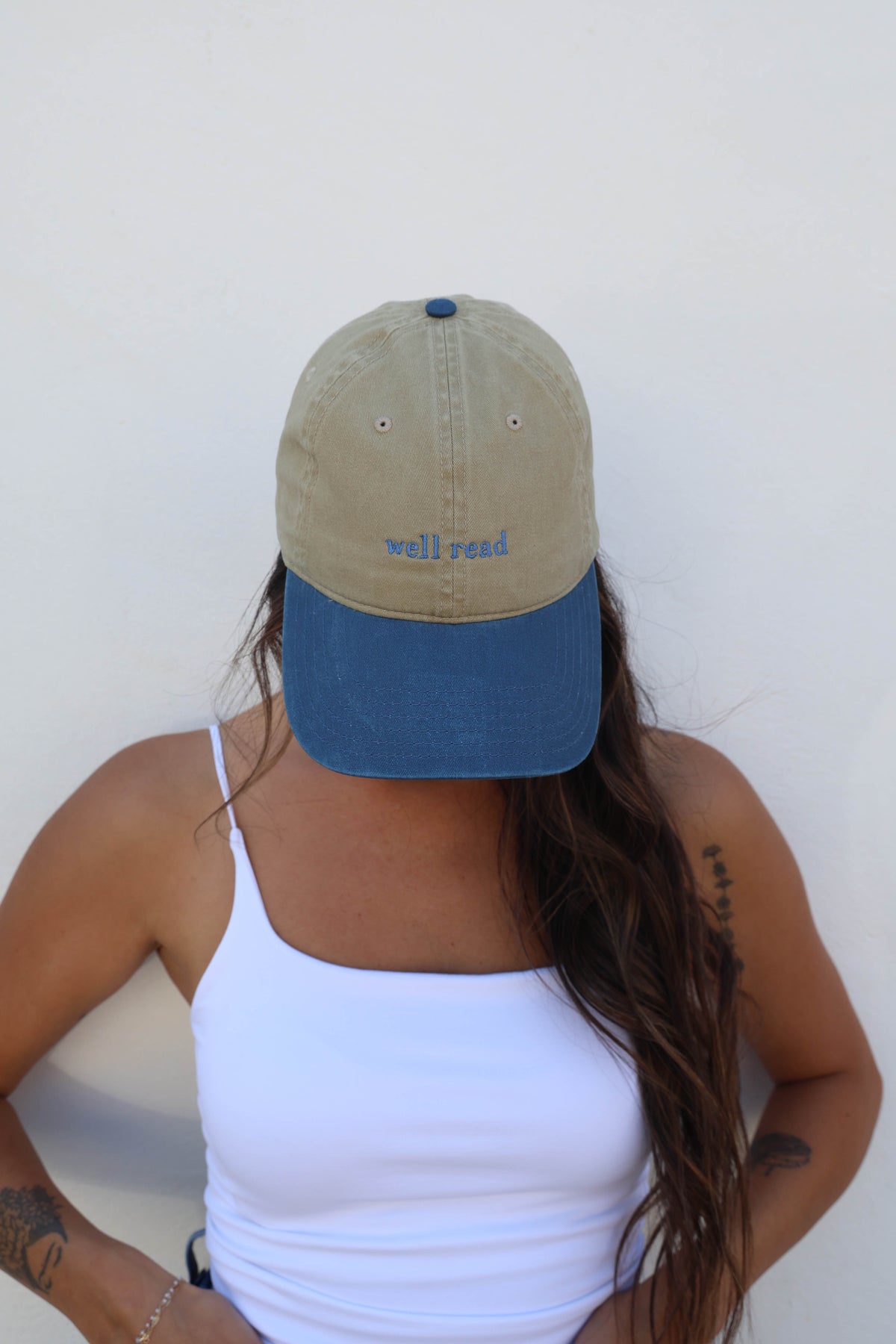 Woman wearing a hat against a white wall