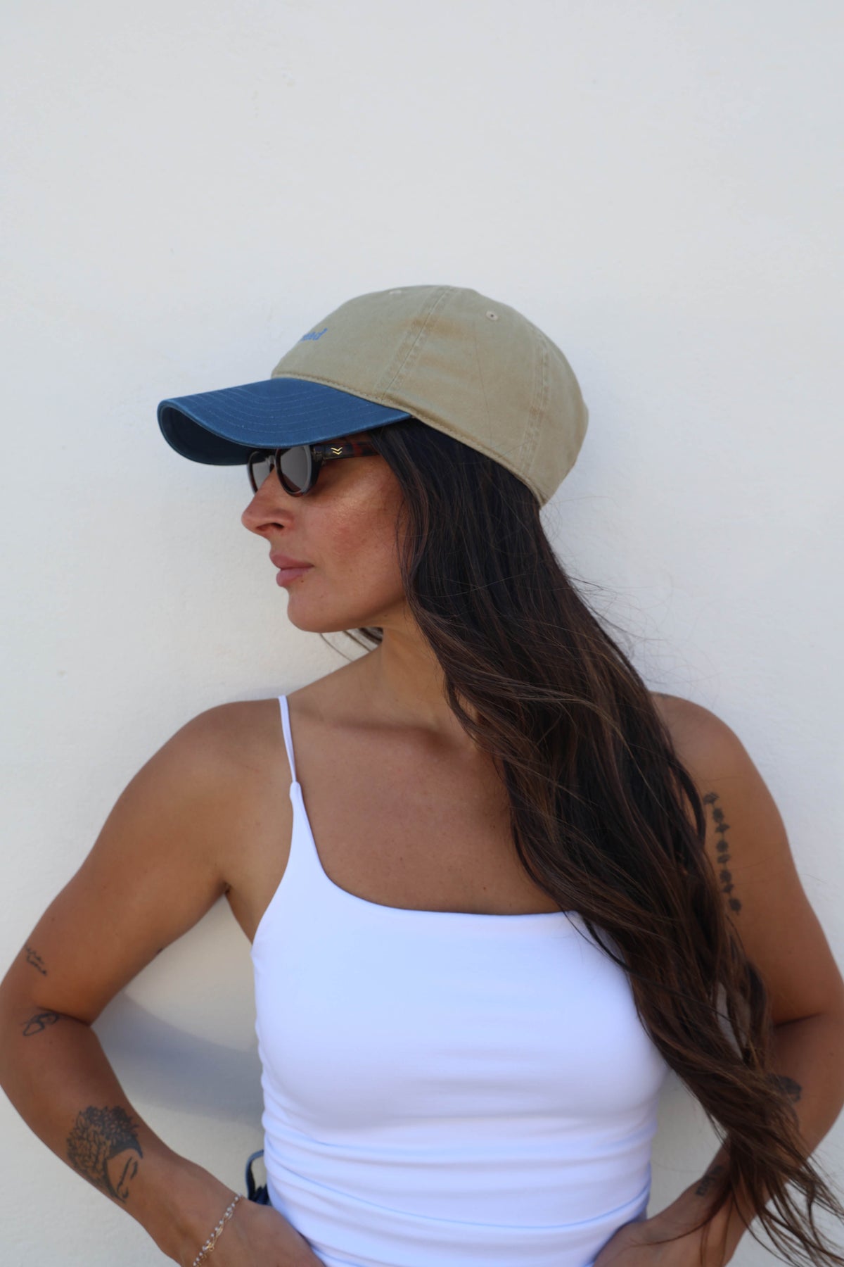 Woman wearing a hat against a white wall