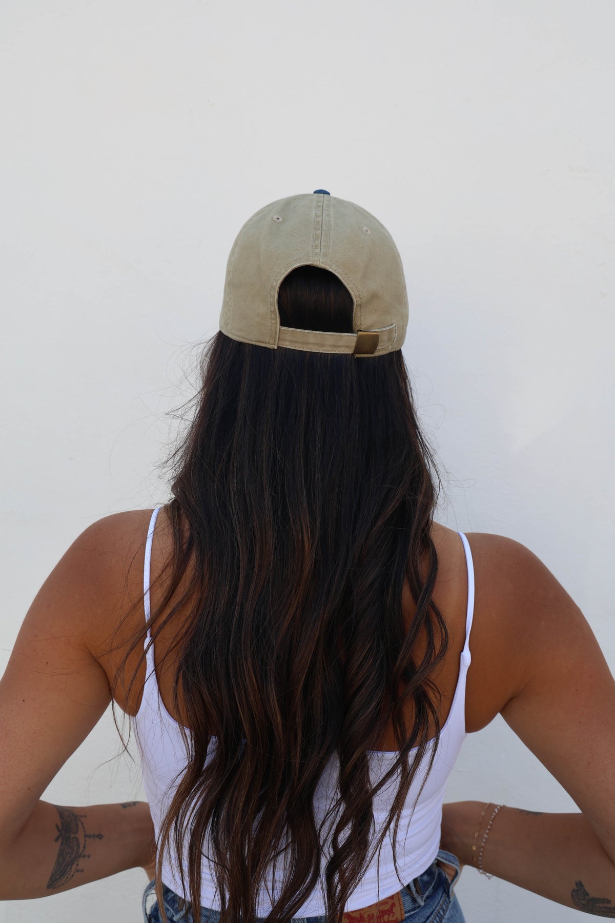 Woman wearing a hat against a white wall