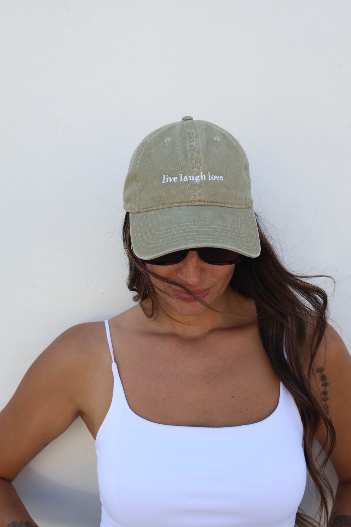 Woman wearing a hat against a white wall