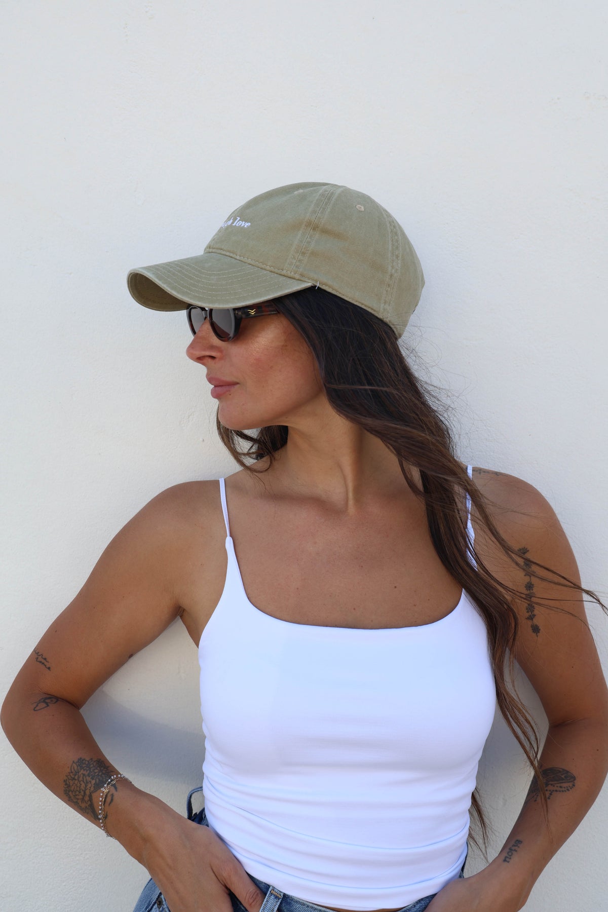 Woman wearing a hat against a white wall