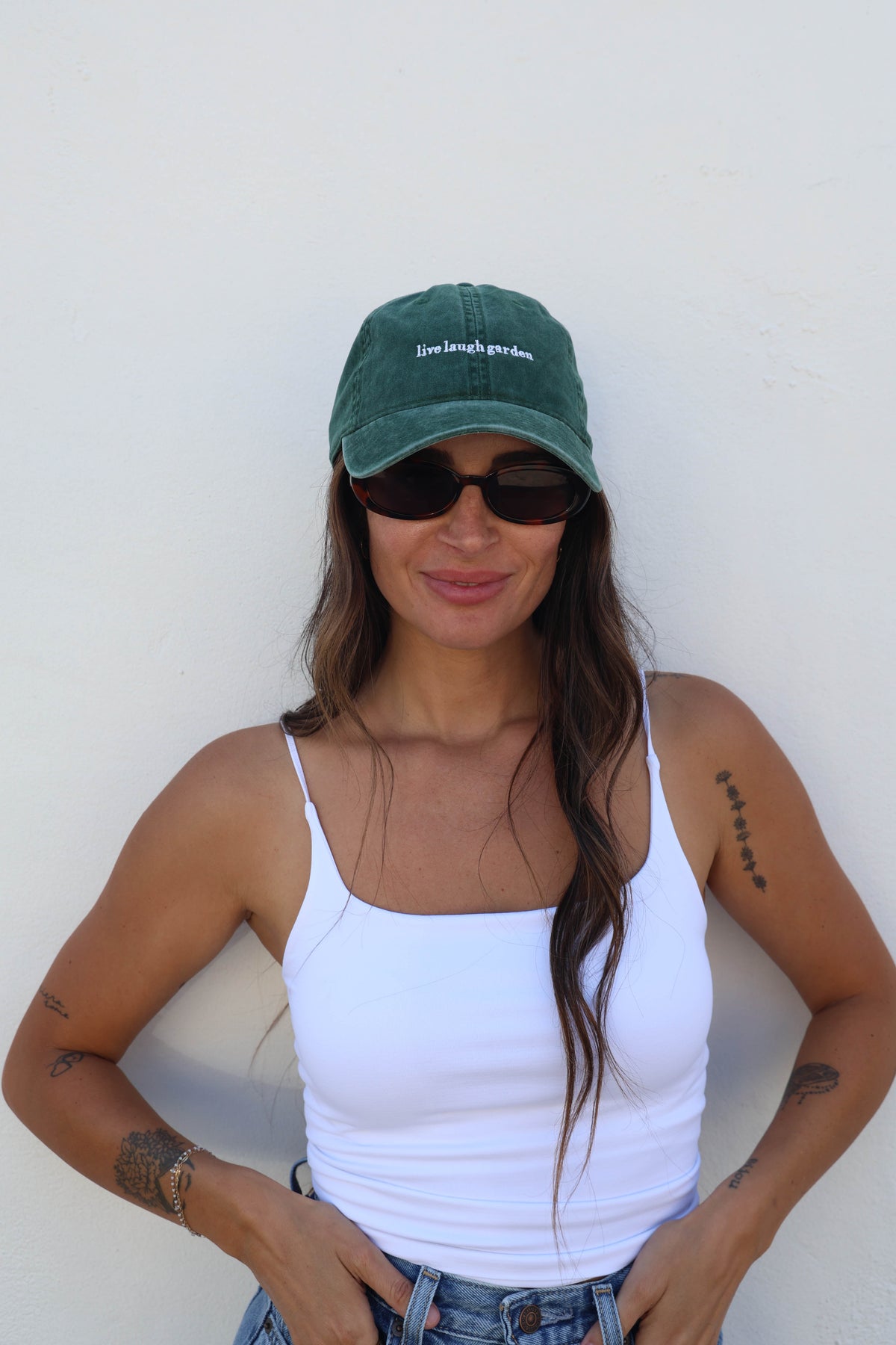 Woman wearing a hat against a white wall