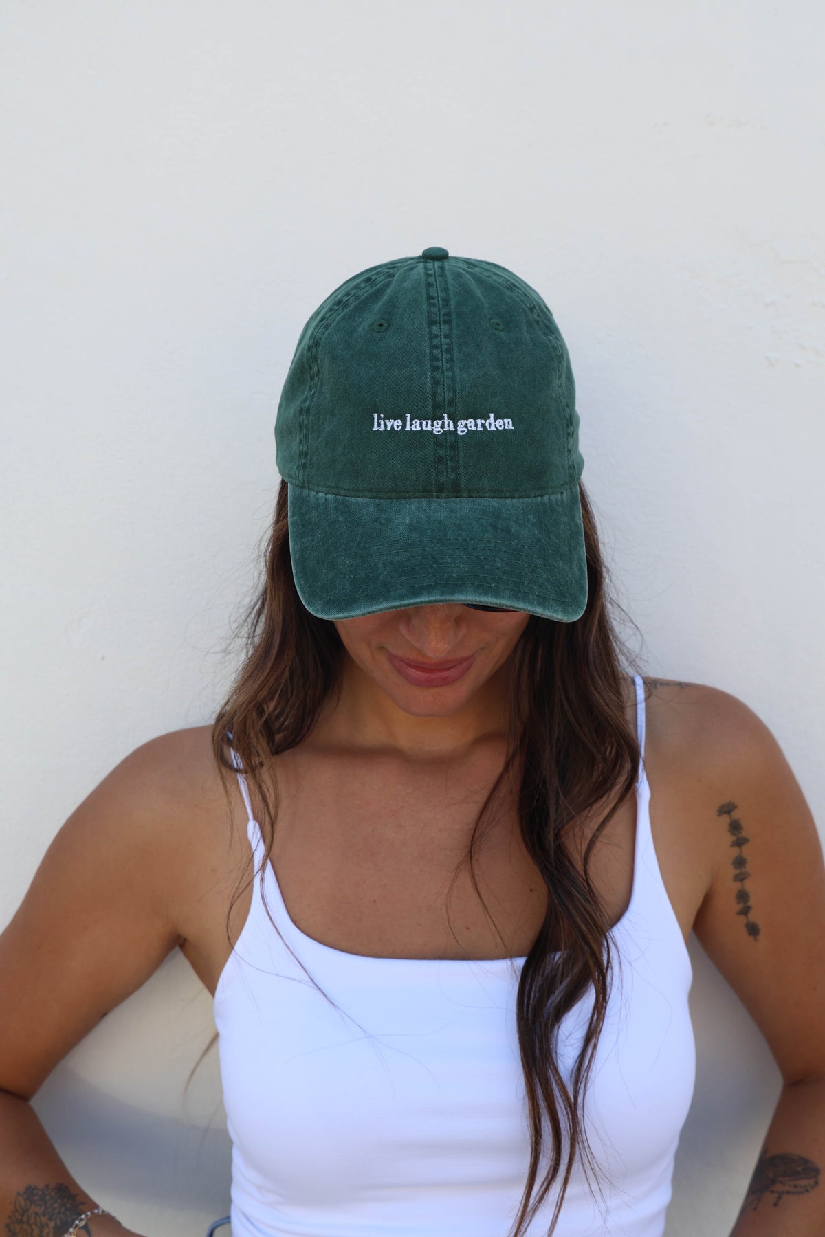 Woman wearing a hat against a white wall