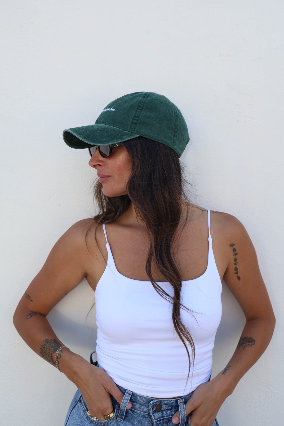 Woman wearing a hat against a white wall