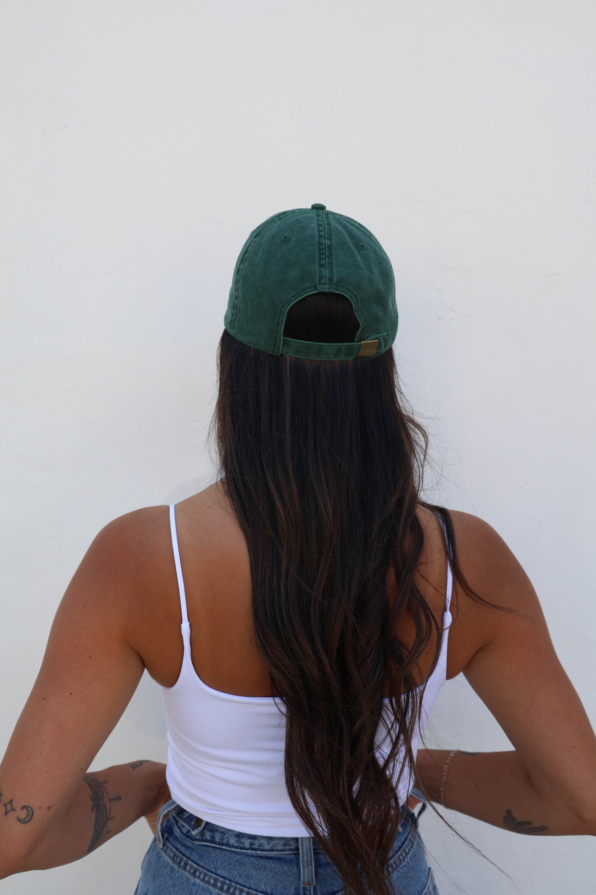Woman wearing a hat against a white wall