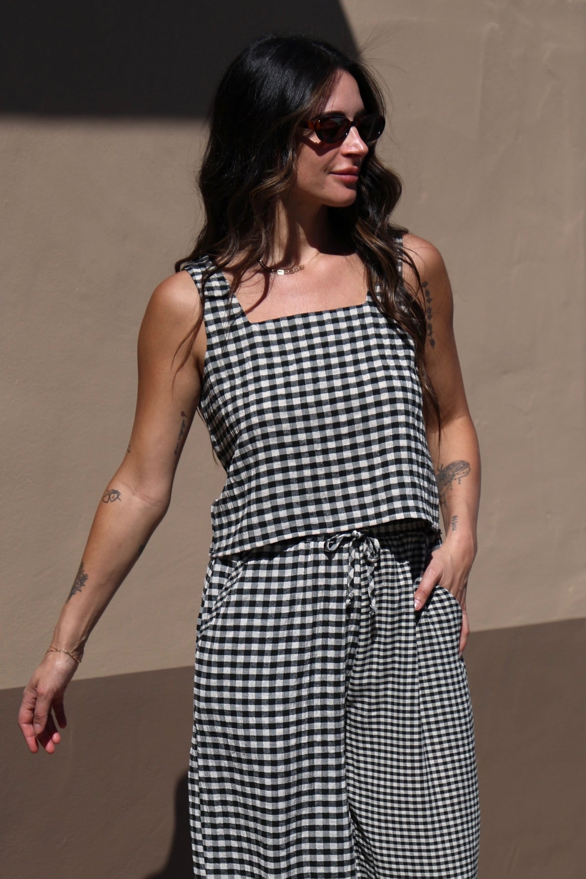 Woman wearing a black and white checkered outfit against a brown background