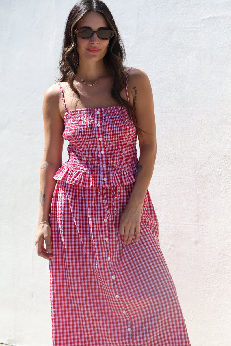 Woman wearing a red and white checkered dress against a white background