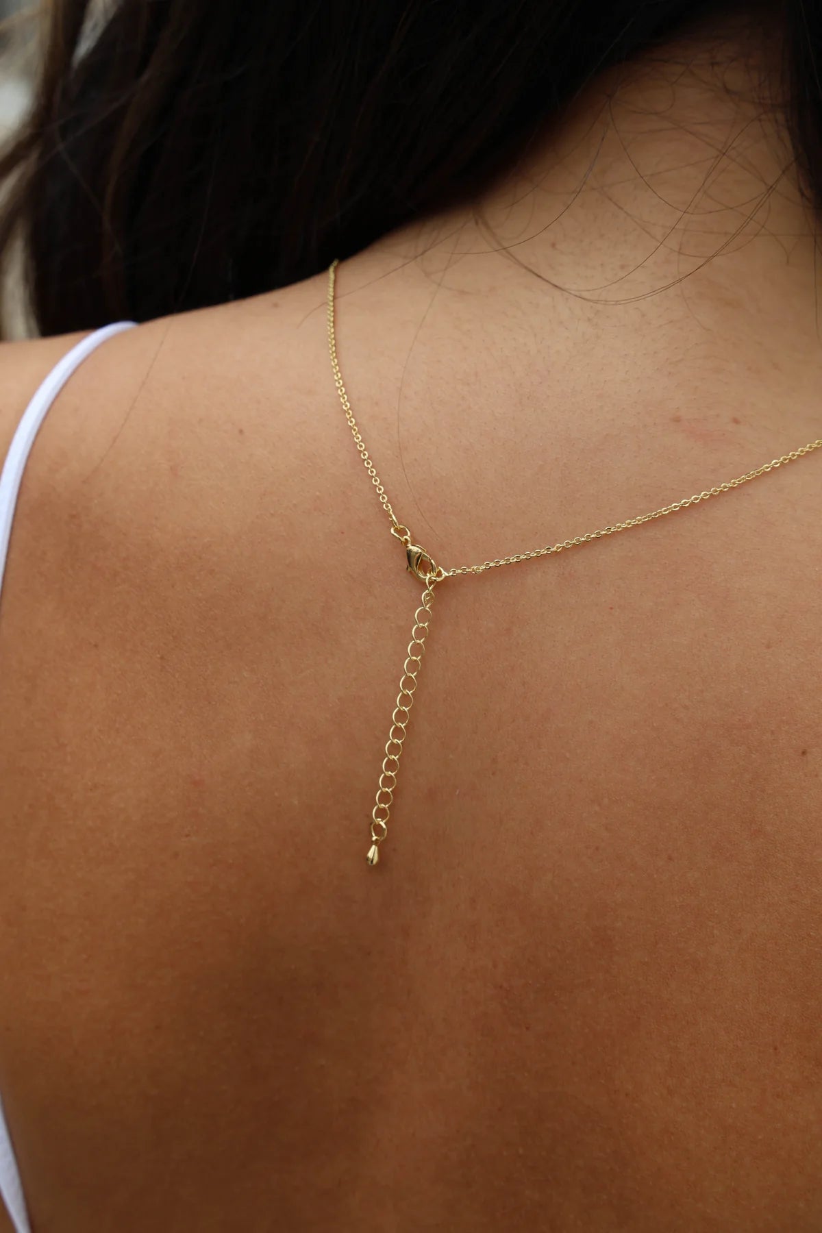 Gold necklace on a person's neck with a blurred background