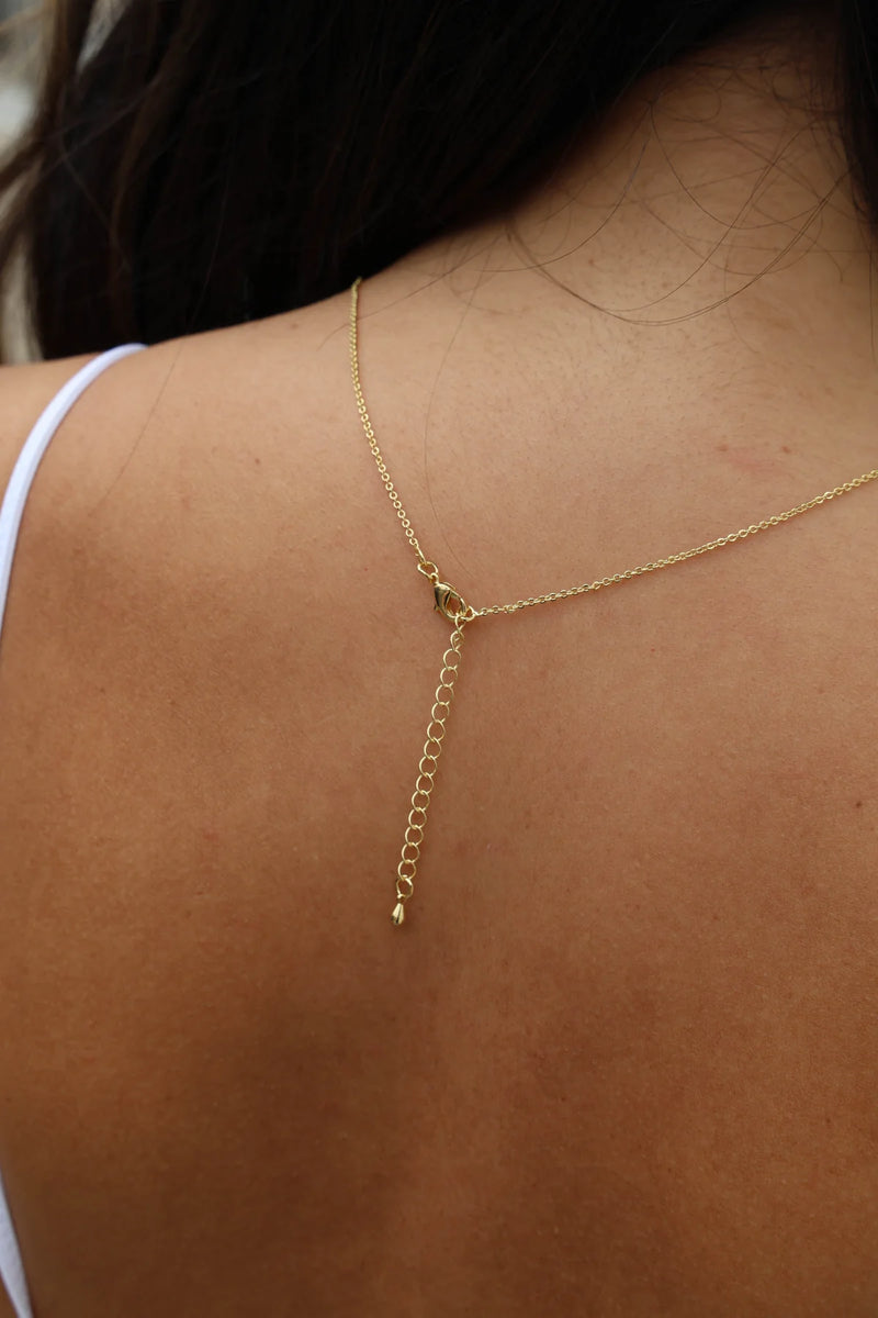 Gold necklace on a person's neck with a blurred background