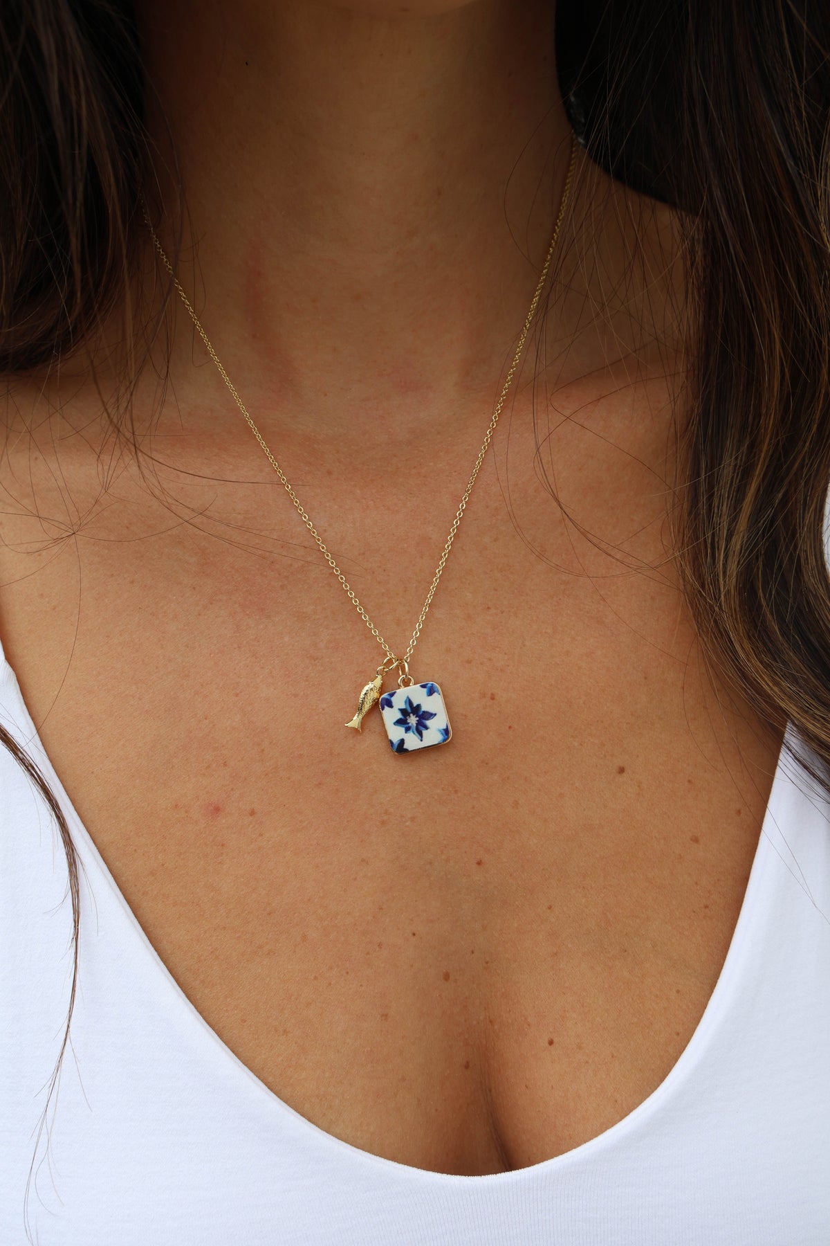Necklace with a blue floral pendant on a white background