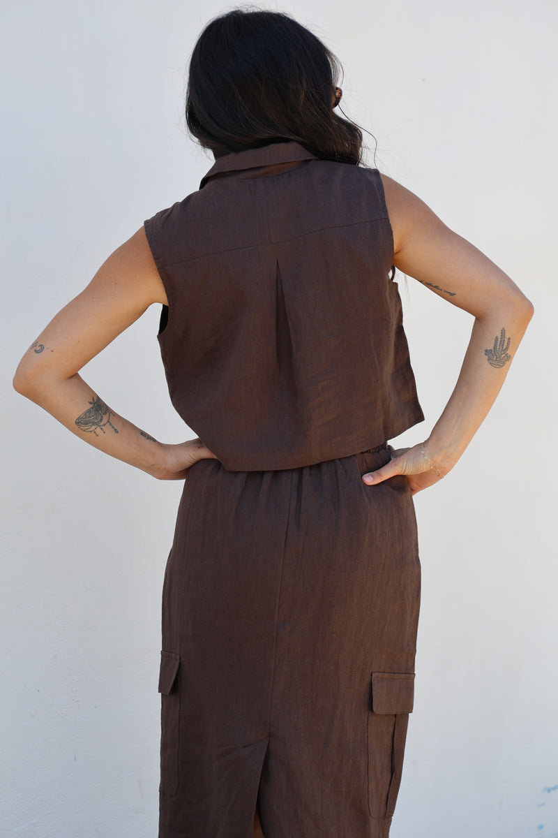 Person wearing a brown dress against a white background