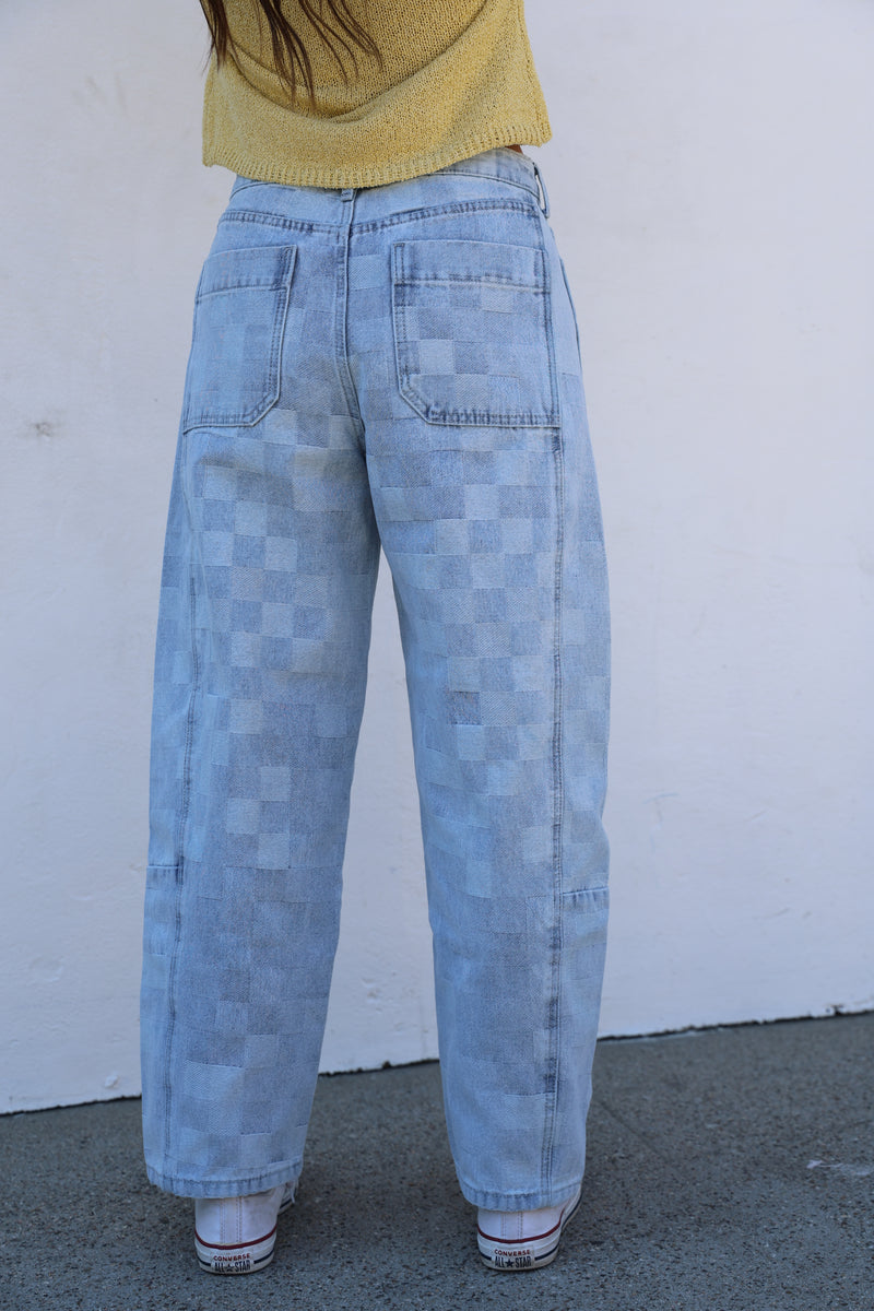 Person wearing light blue jeans on a white background