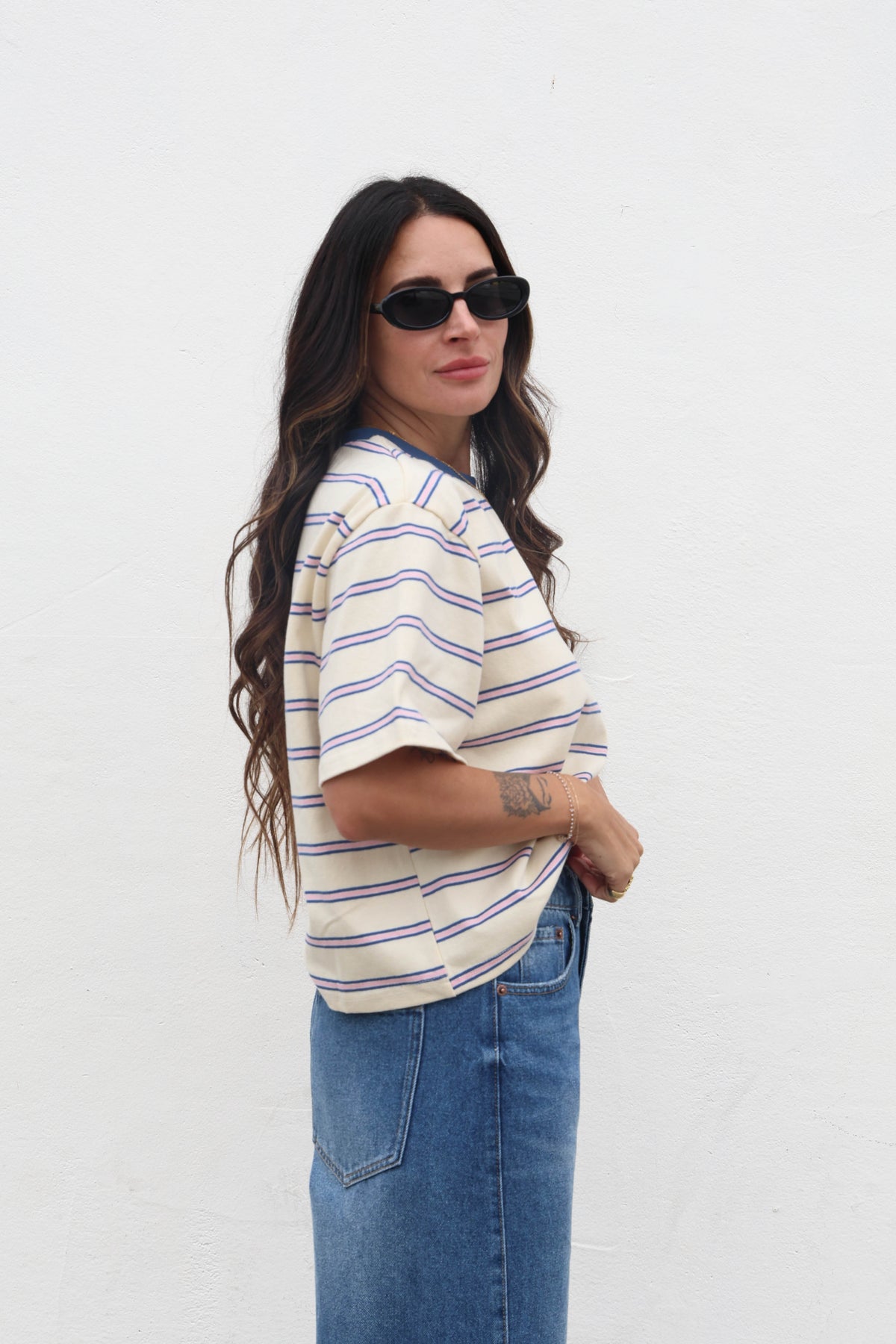 Woman wearing a striped shirt and sunglasses on a white background