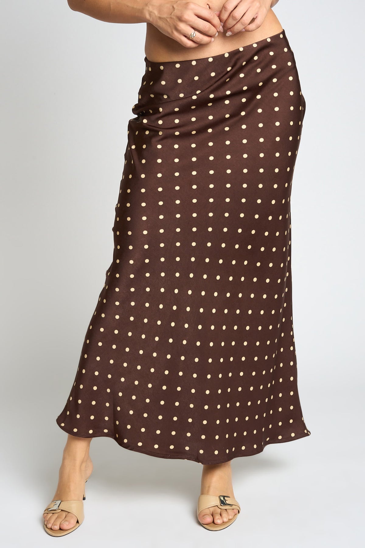 Brown polka dot skirt worn by a person on a plain background