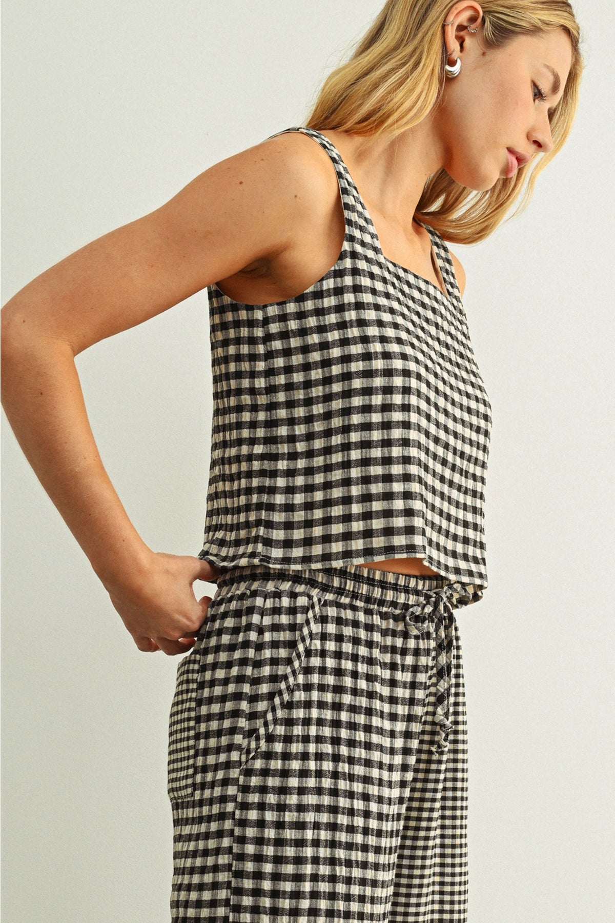 Woman wearing a black and white checkered dress against a plain background