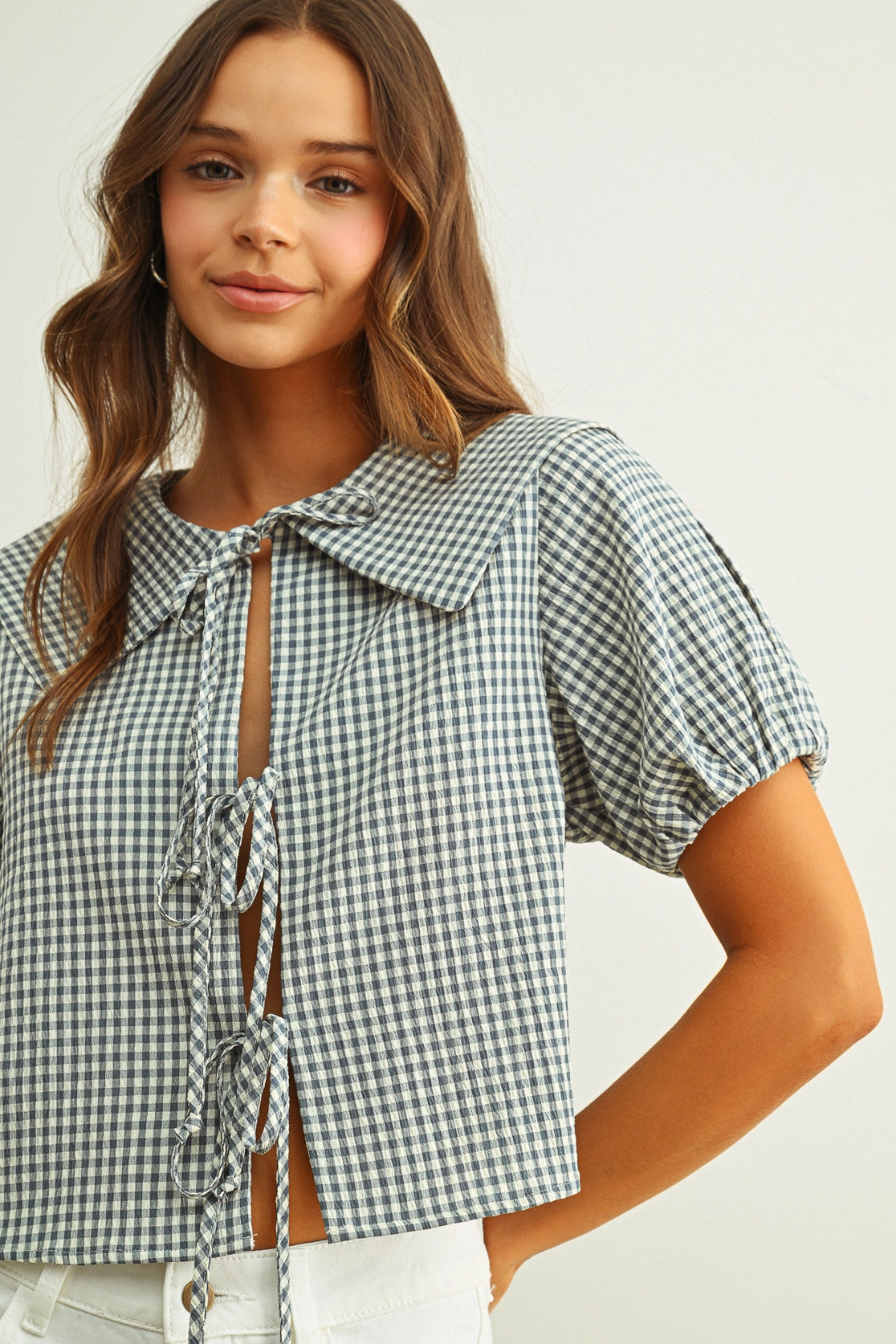 Woman wearing a checkered blouse with a white background