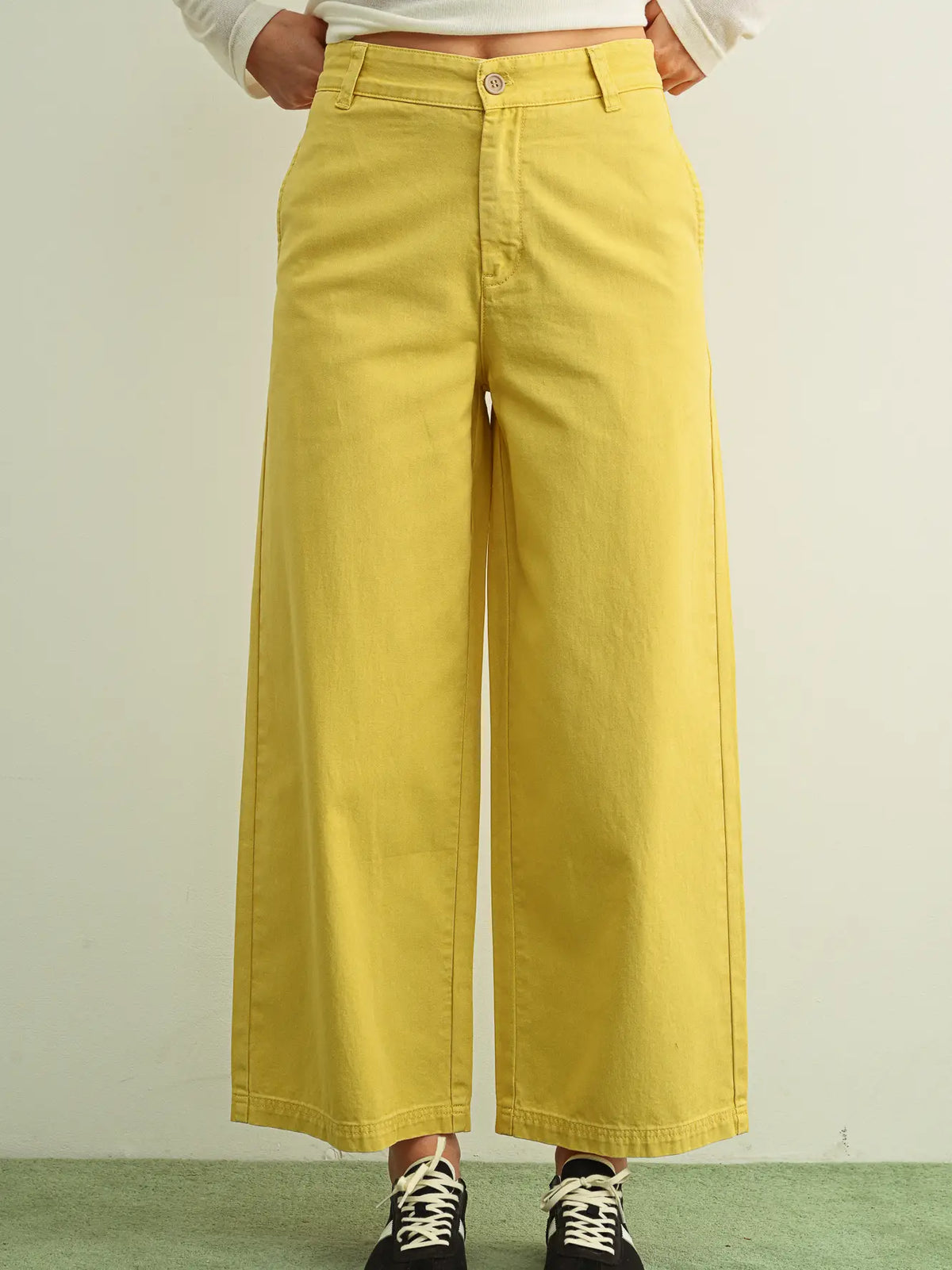 Yellow wide-leg pants worn by a person on a plain background