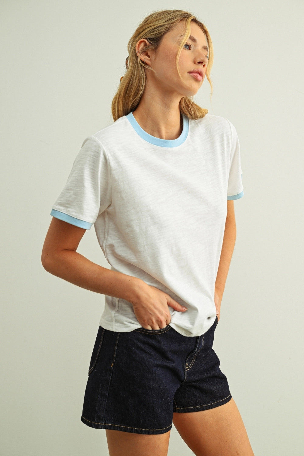 Woman modeling a white tee with a blue collar 