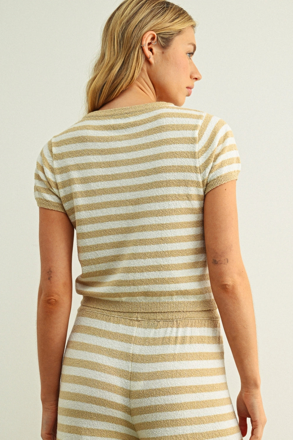Woman wearing a striped dress with a neutral background
