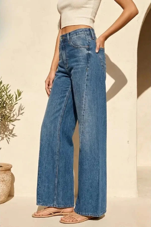 Person wearing blue wide-leg jeans with a neutral background